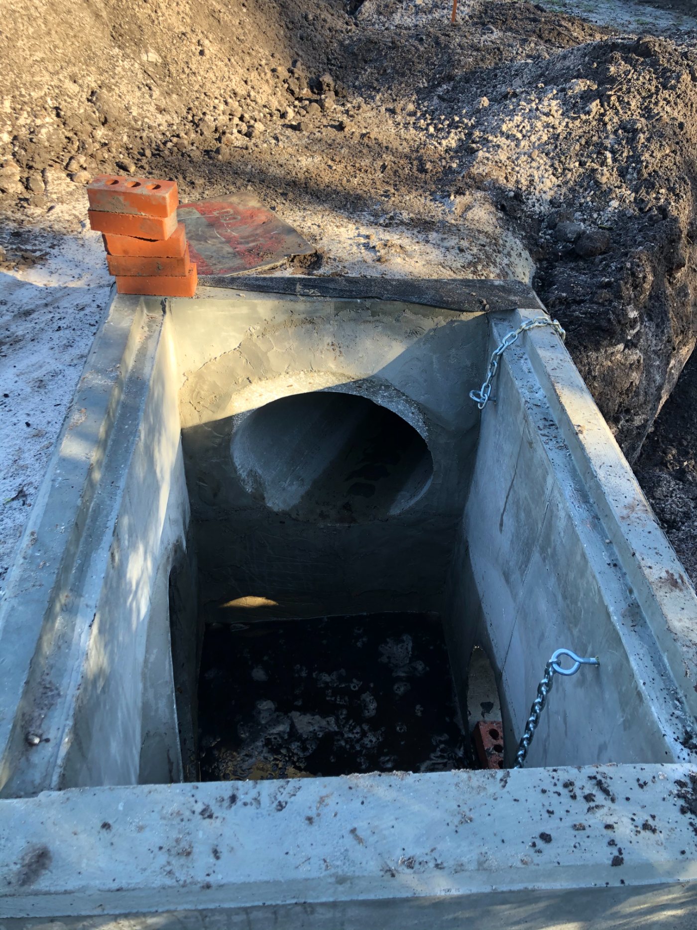 A precast concrete stormwater structure set into an open trench