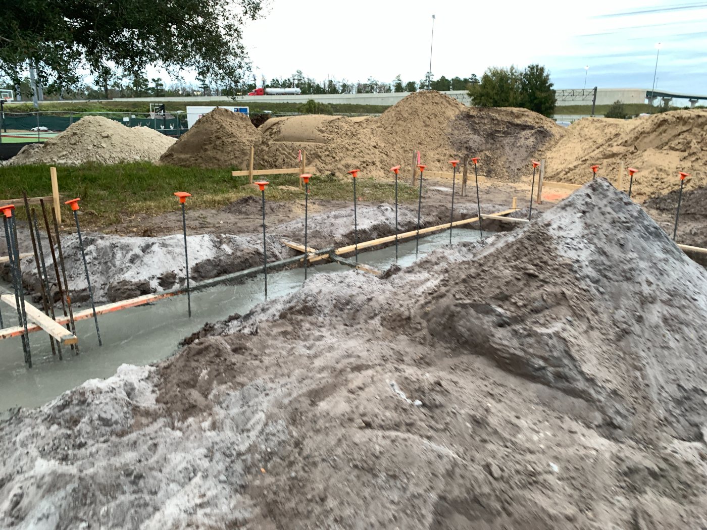 Footing trenches with rebar dowels and freshly poured concrete