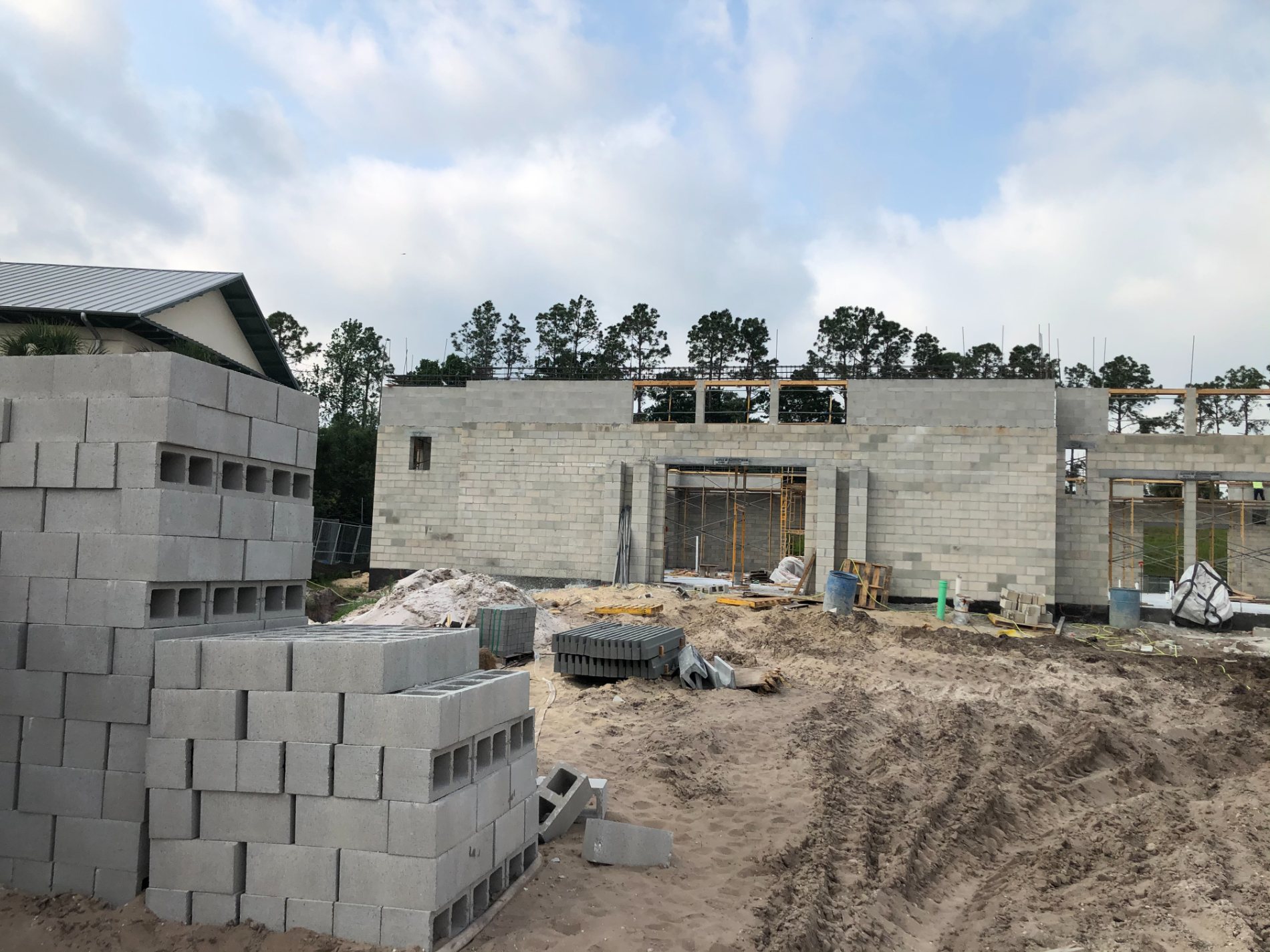 The masonry building shell rising against an open Florida sky, block staged in the foreground