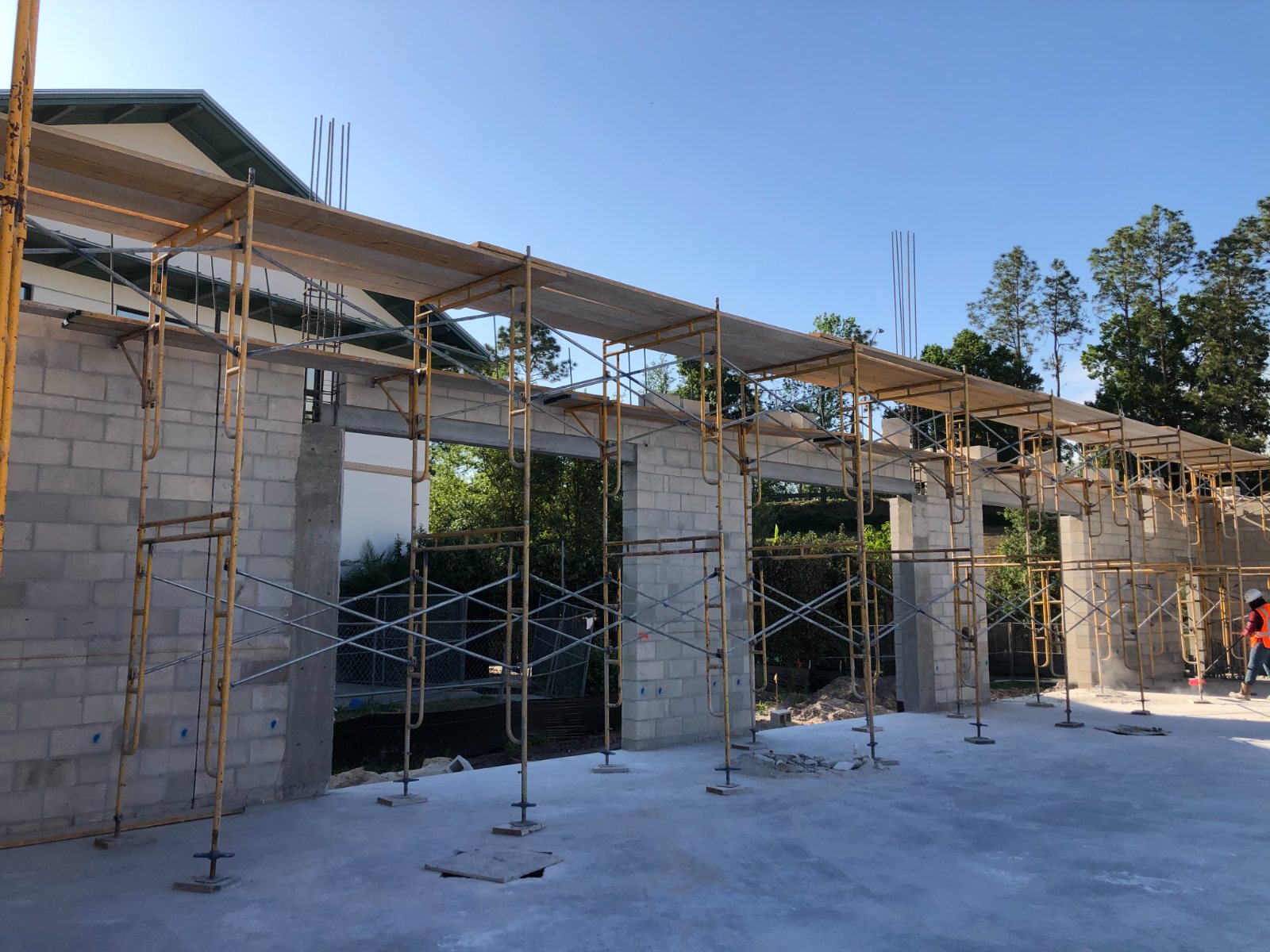 Scaffolding along block walls as lintel formwork is set above the door openings