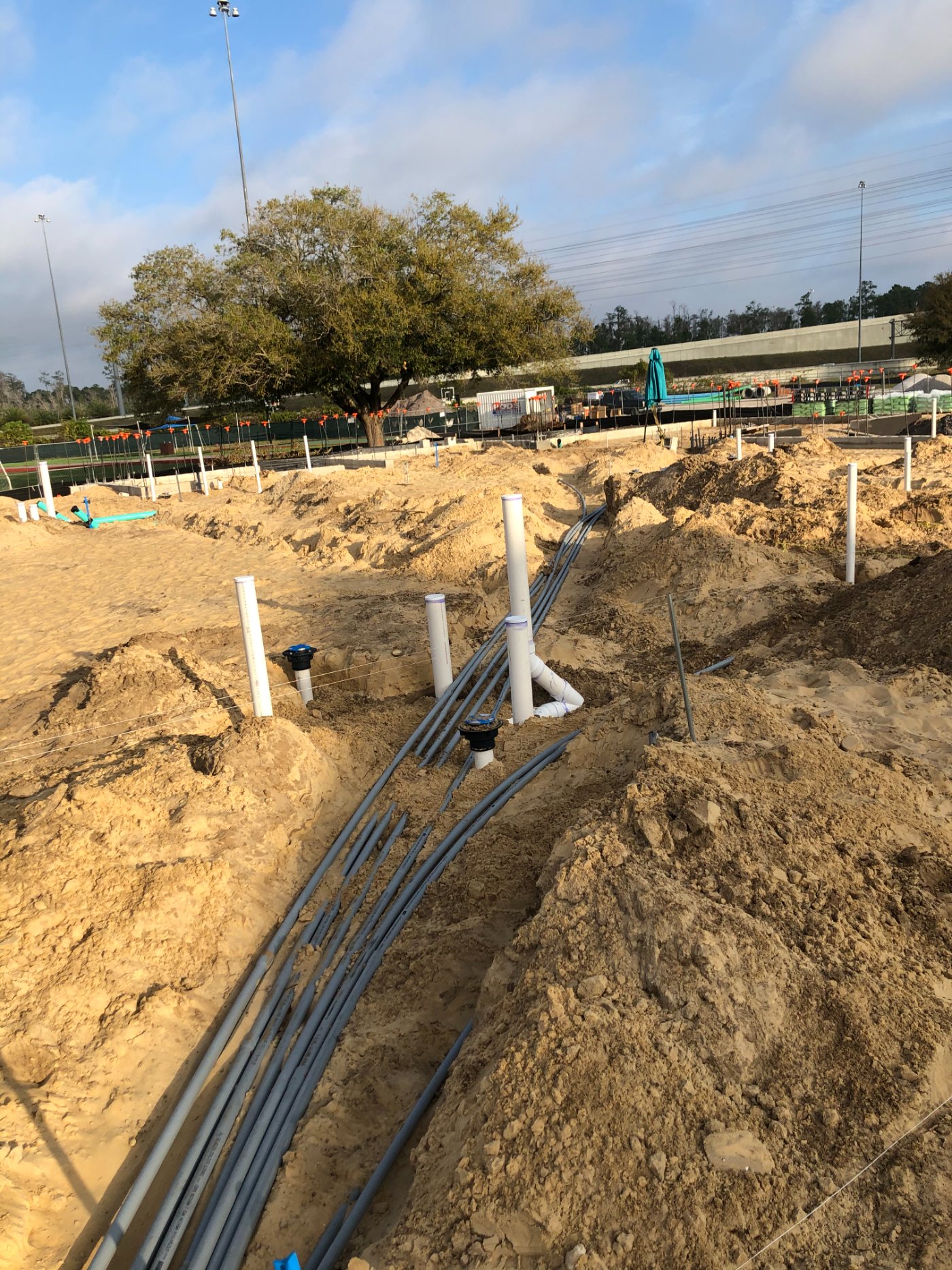 Utility rough-in laid across the graded school pad, exactly where the finished campus needed it