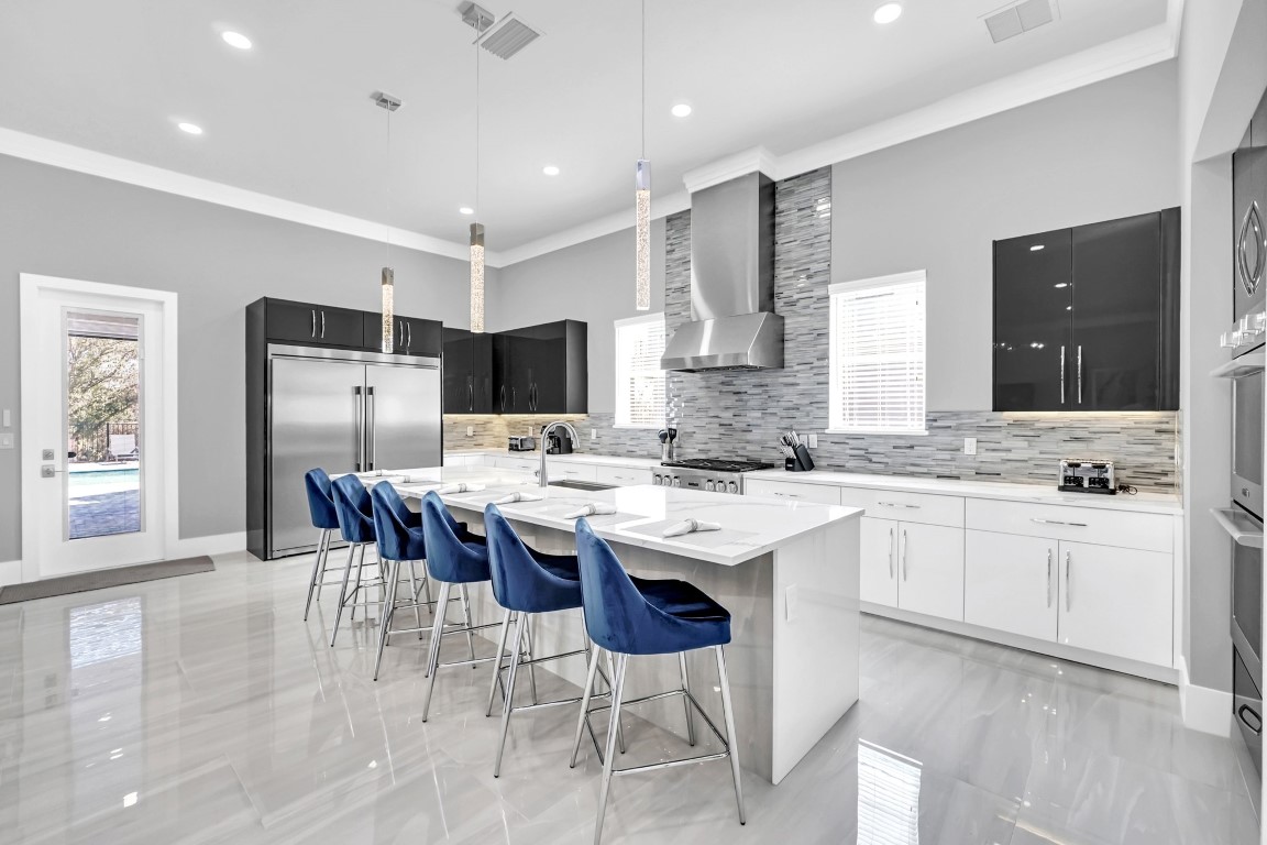 Chef's kitchen with a white island and blue counter stools