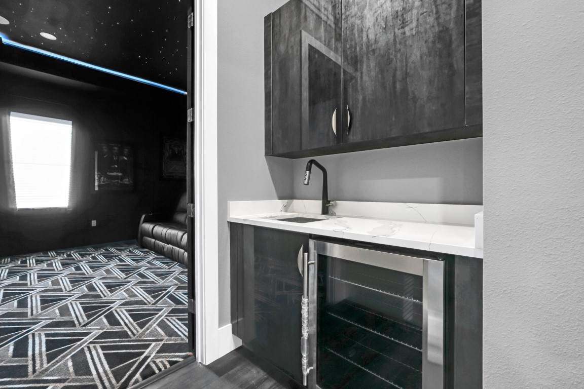 Blacked-out home cinema with a wet bar and starlit ceiling