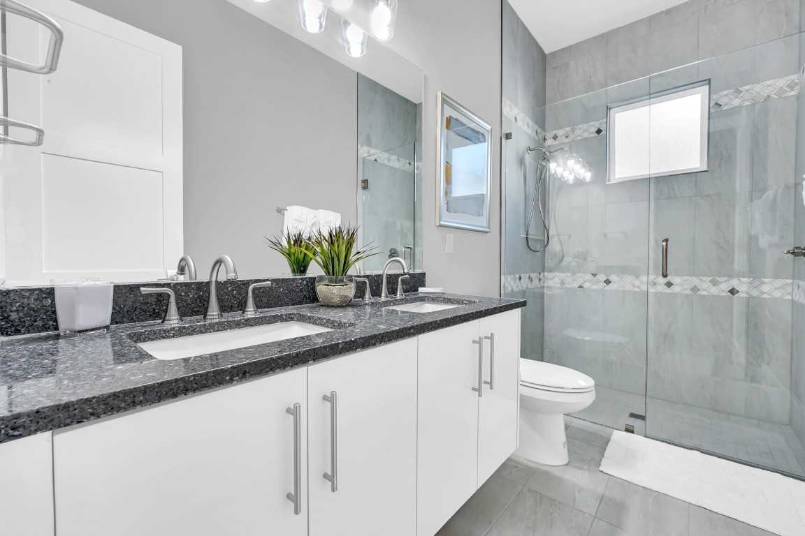 Guest bath with a glass walk-in shower and a granite vanity
