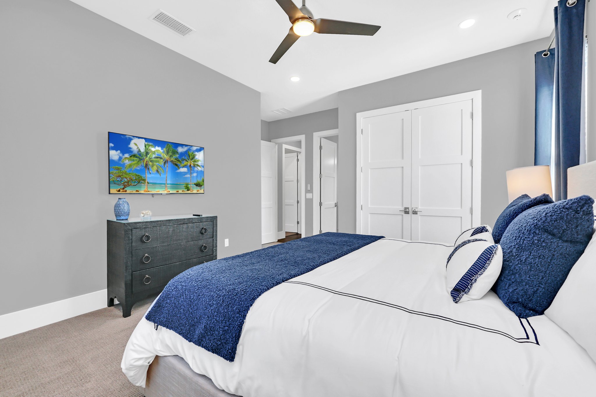 Guest bedroom with a navy accent wall and coastal styling
