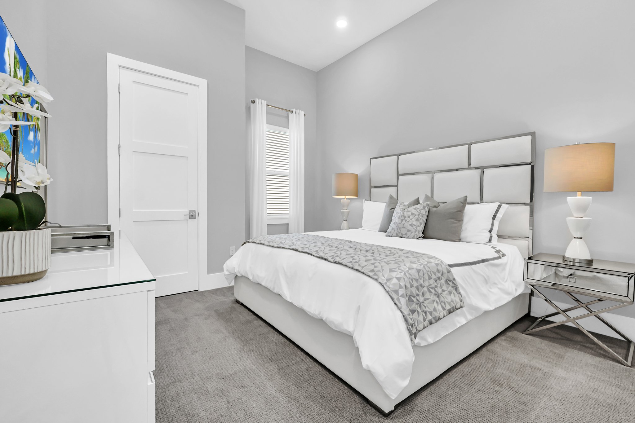 Guest bedroom in soft grey with an upholstered headboard