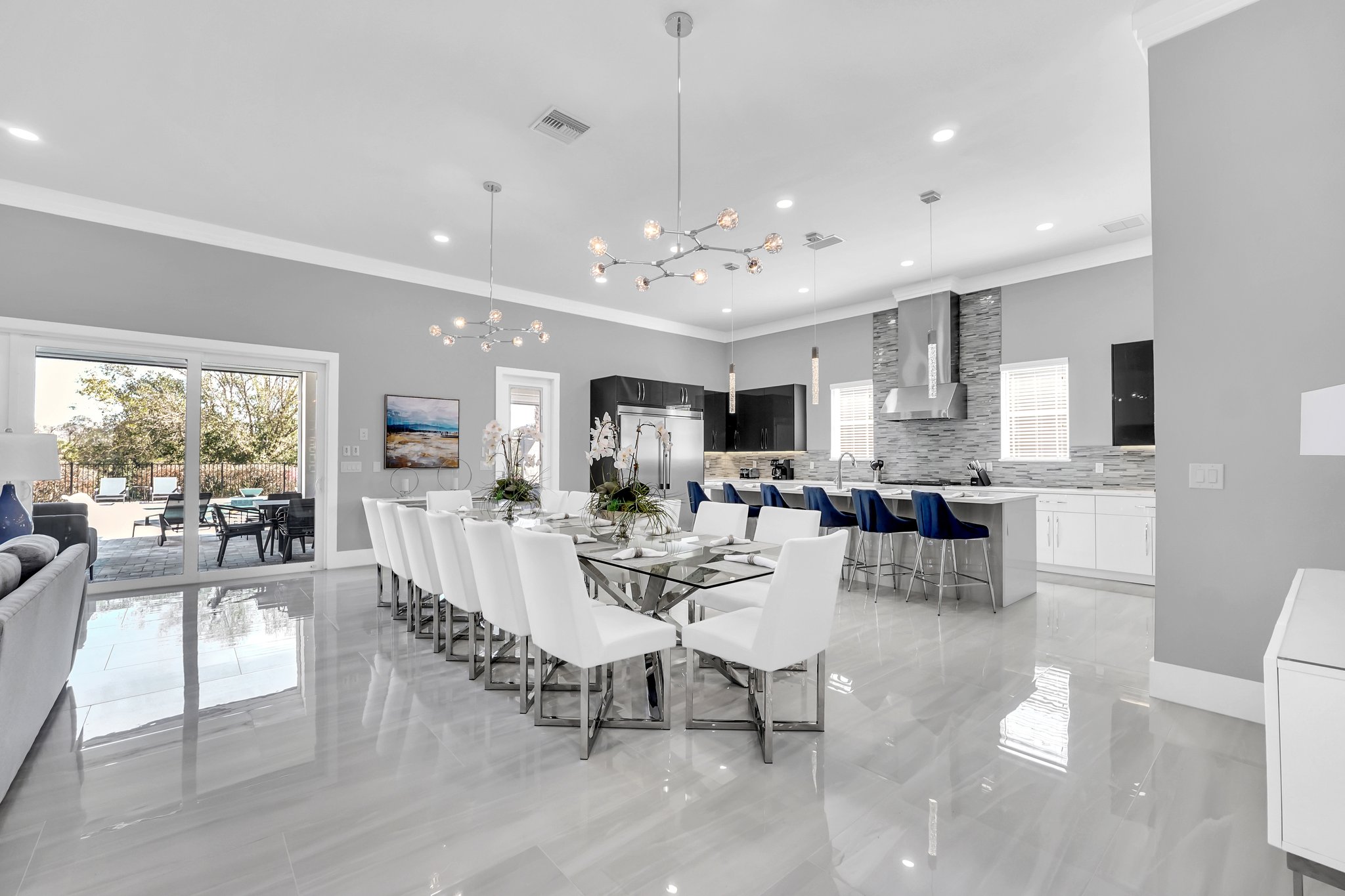 Formal dining table for twelve, open to the chef's kitchen and the pool beyond