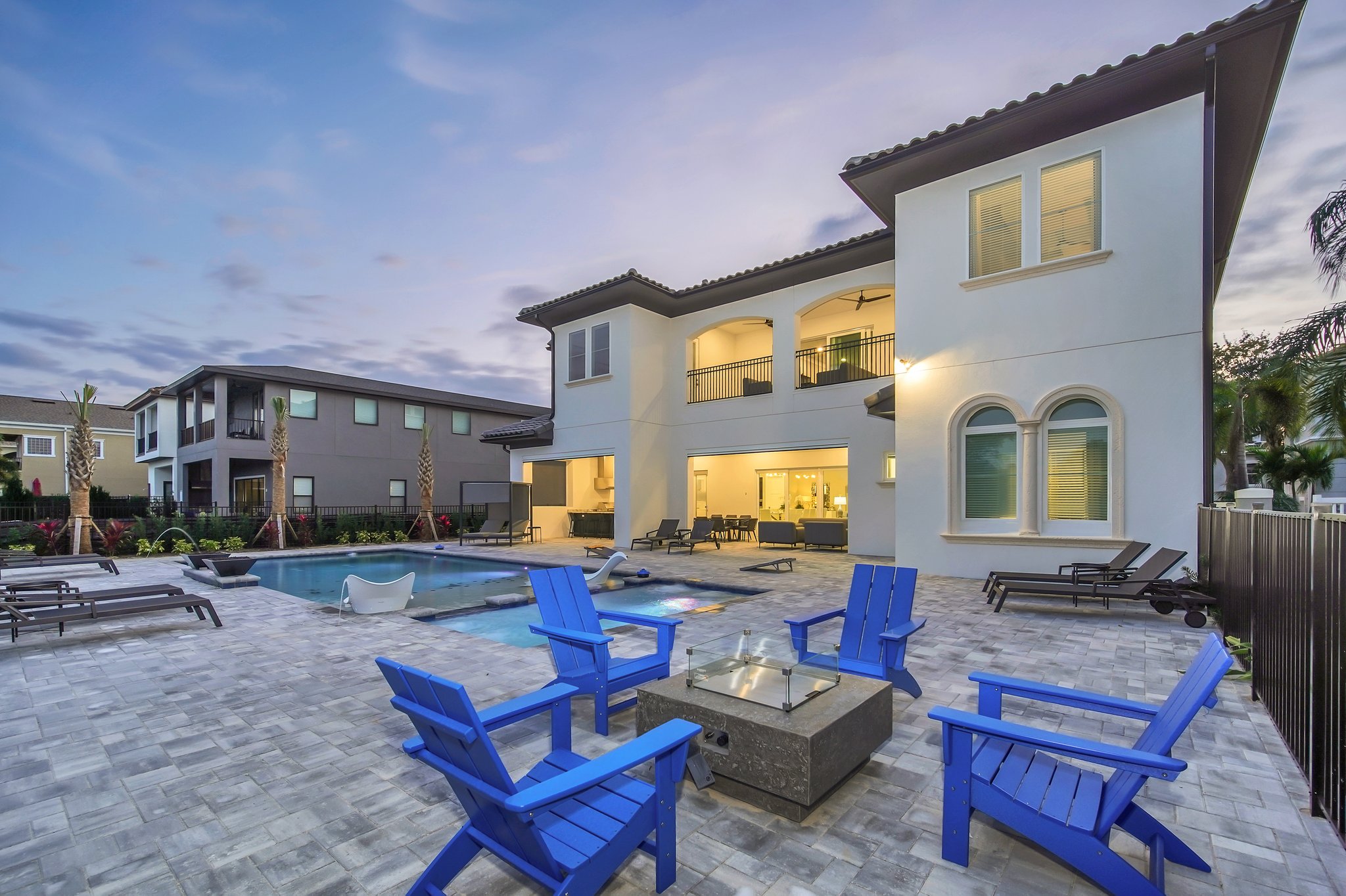 Poolside fire-pit terrace with lounge seating at dusk over the fairway
