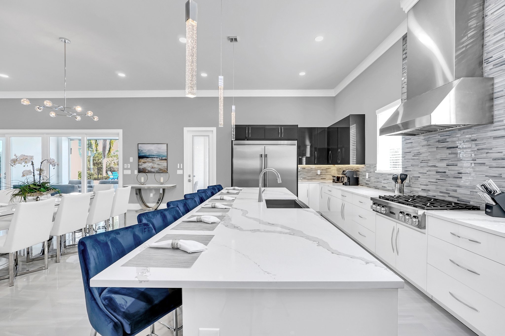 Chef's kitchen with a long waterfall-marble island in forced perspective