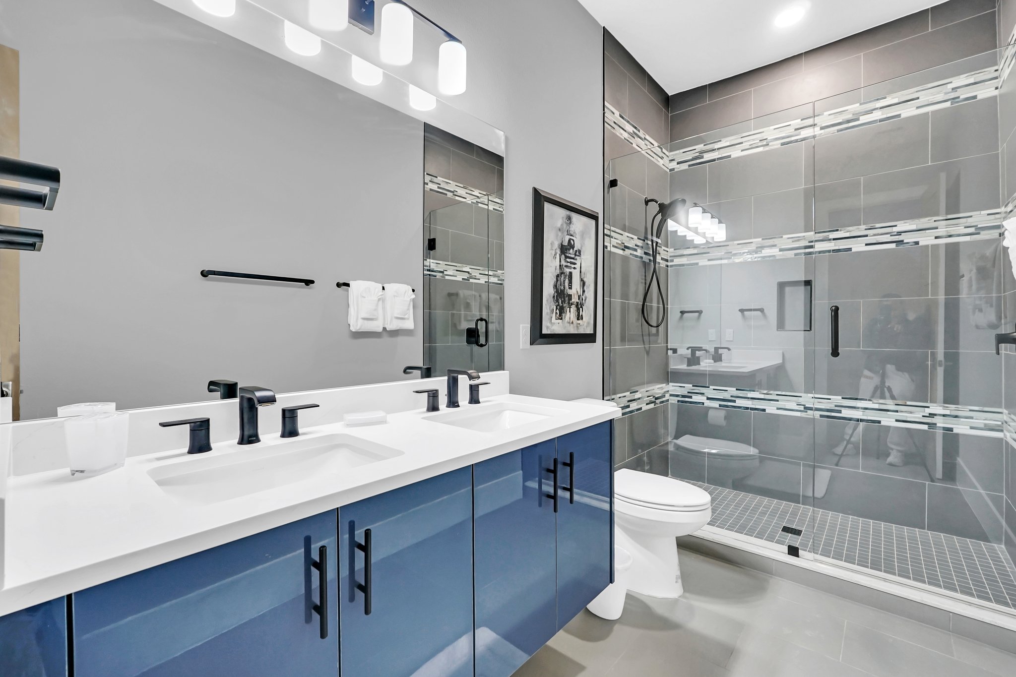 Galaxy suite bathroom with blue-gloss vanity, black fixtures, and droid art