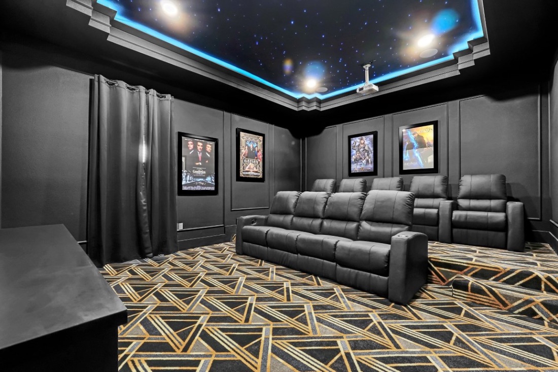 Private cinema with a starlit fiber-optic ceiling, framed posters, and tiered recliners