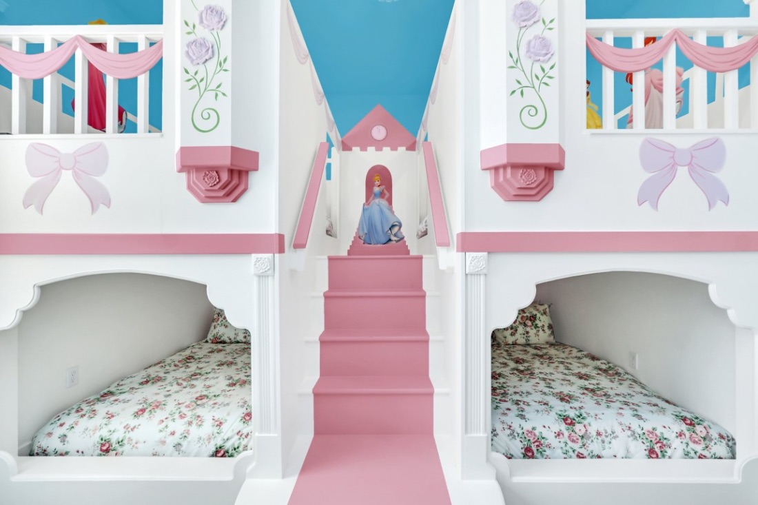 Princess castle bunk room with a painted castle mural, a slide, and floral bedding