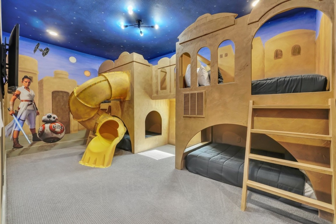 Galaxy-themed bunk room with a hand-painted desert mural and a slide