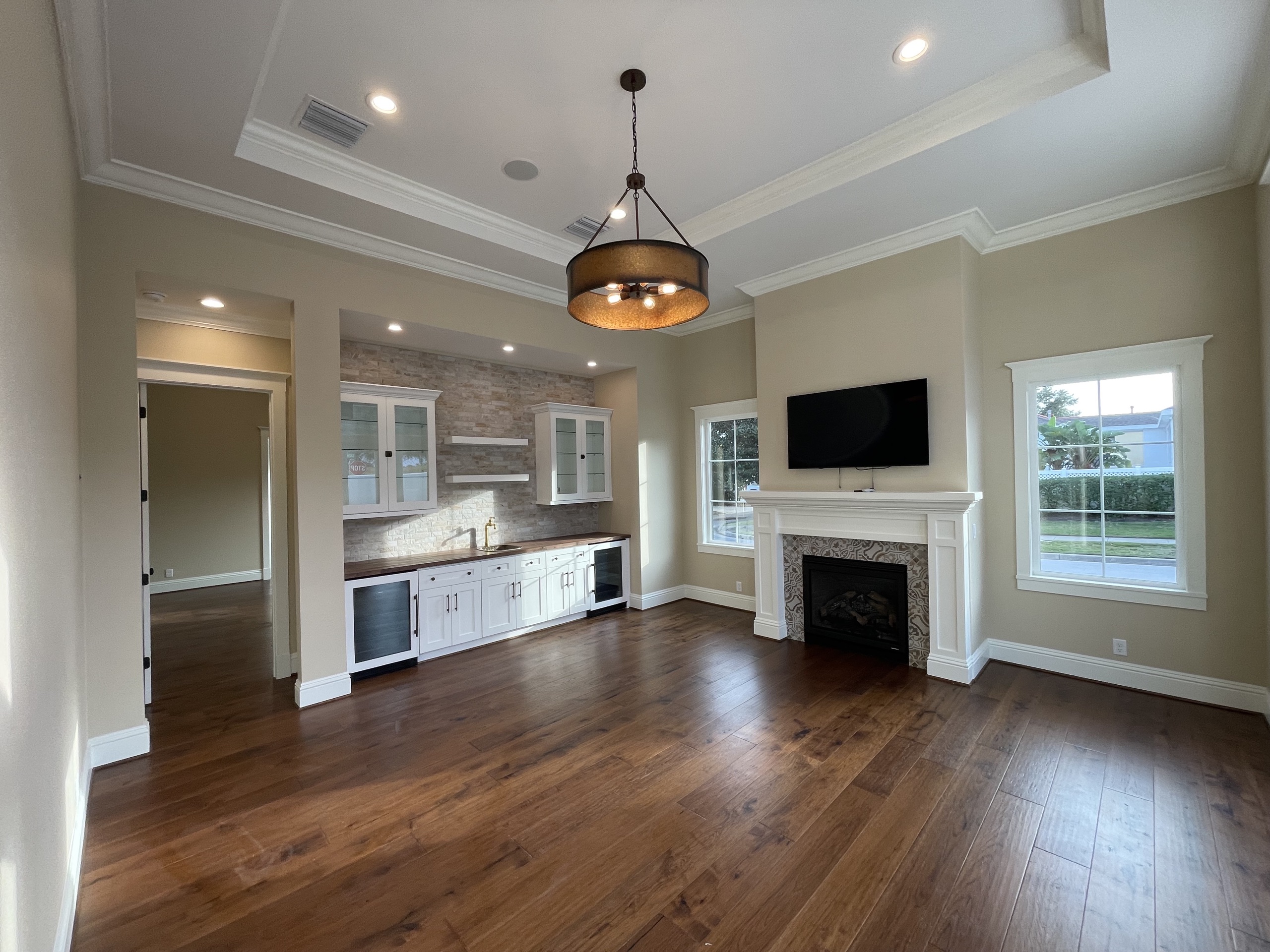 Wet bar with stacked-stone backsplash beside the family room