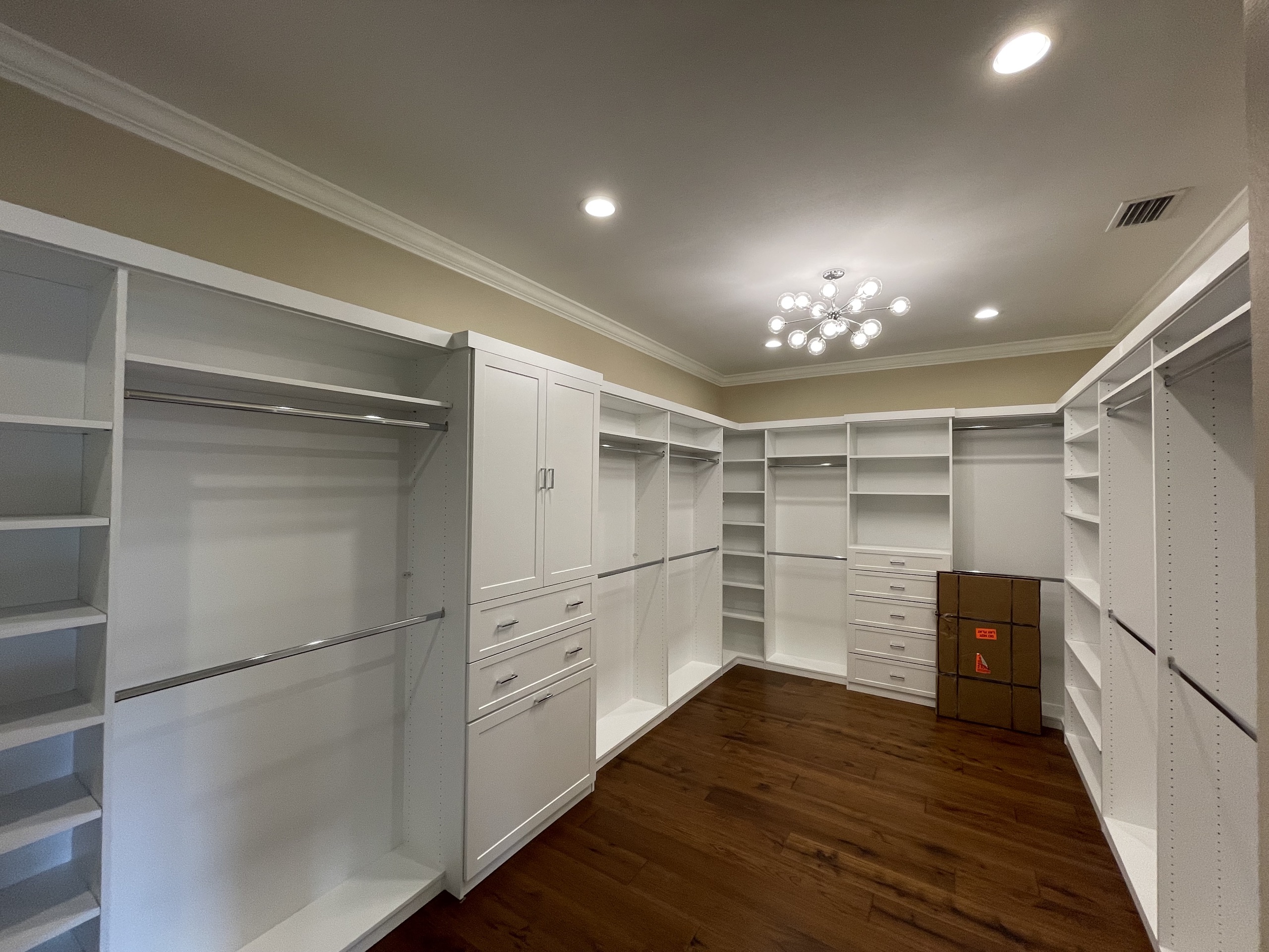 Primary walk-in closet with custom white shelving