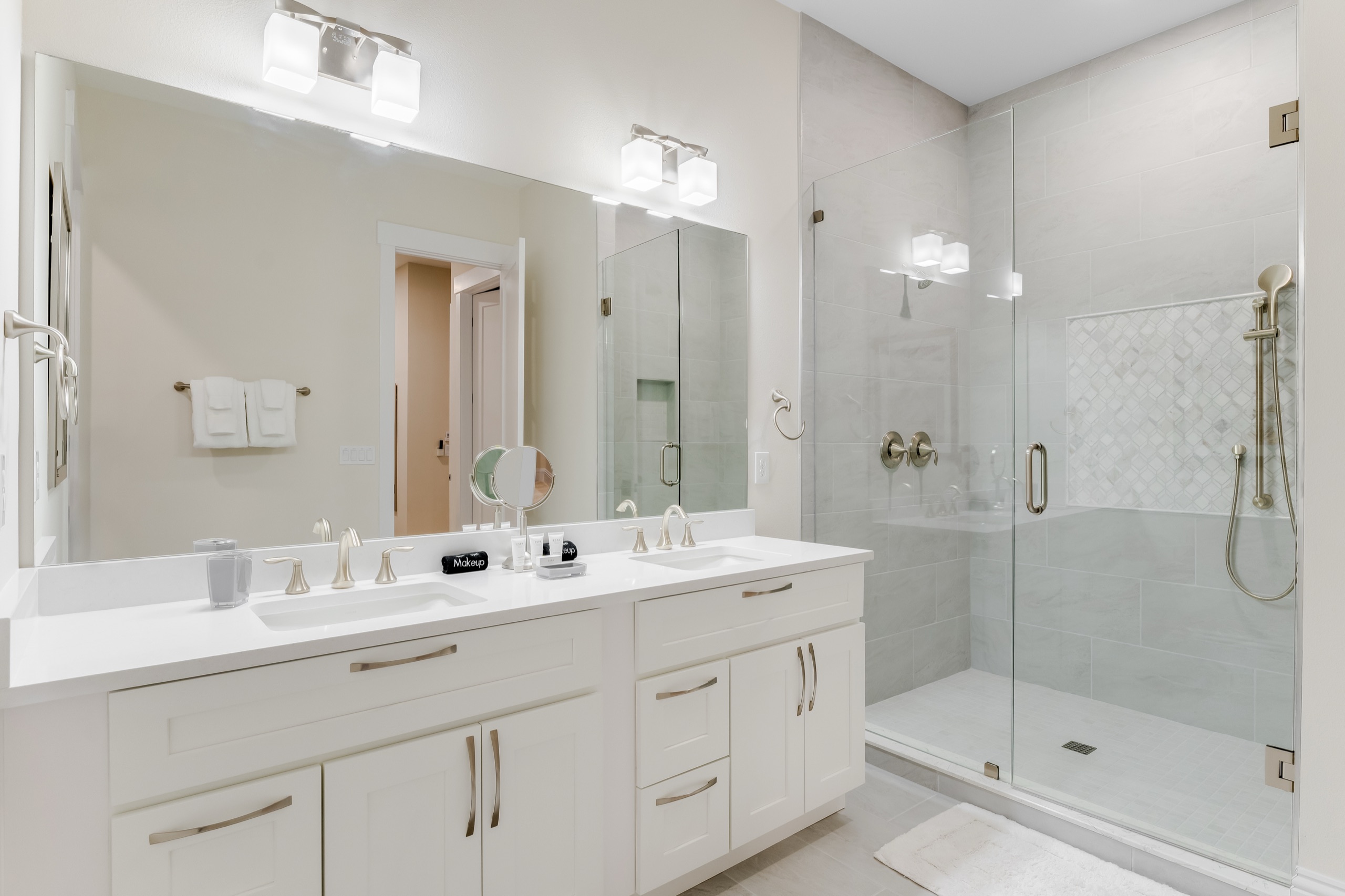 Bright guest bath with a dual vanity and glass shower