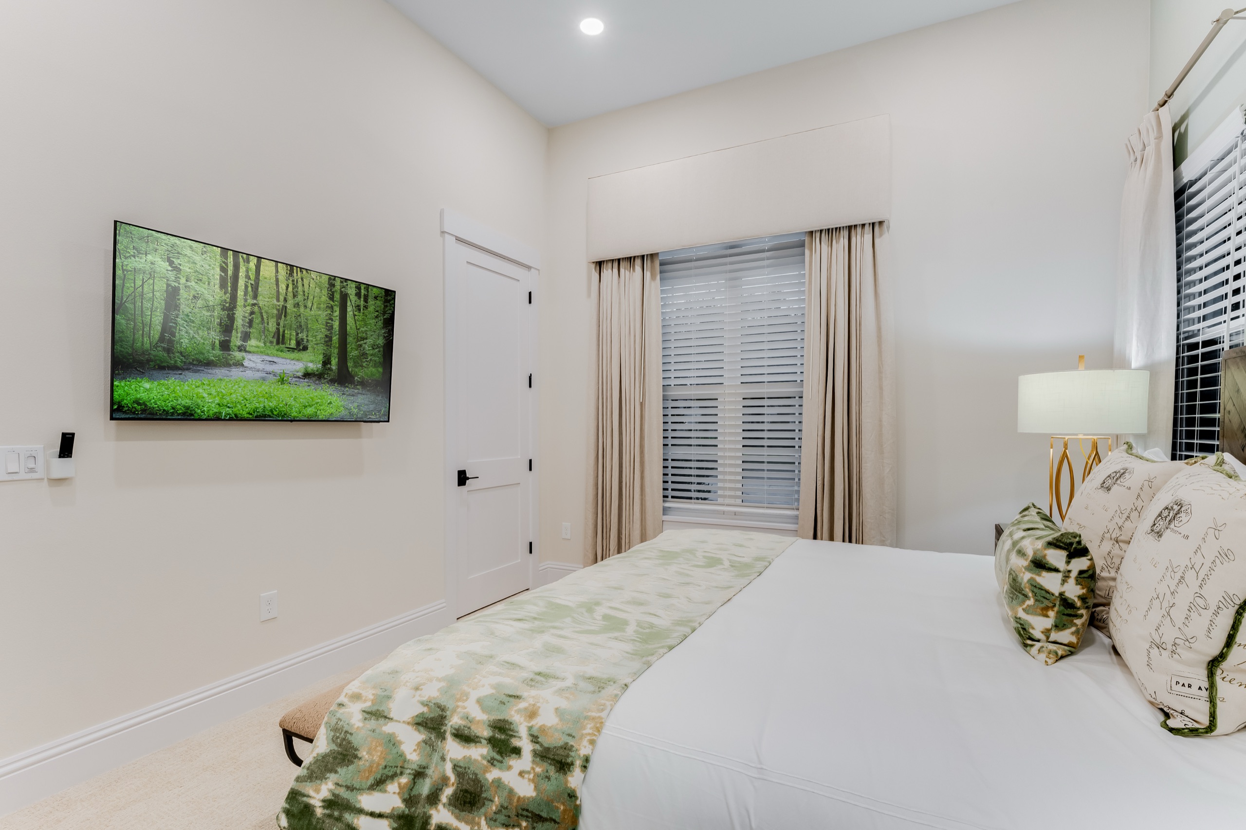 Second downstairs bedroom with a soft green-and-white palette