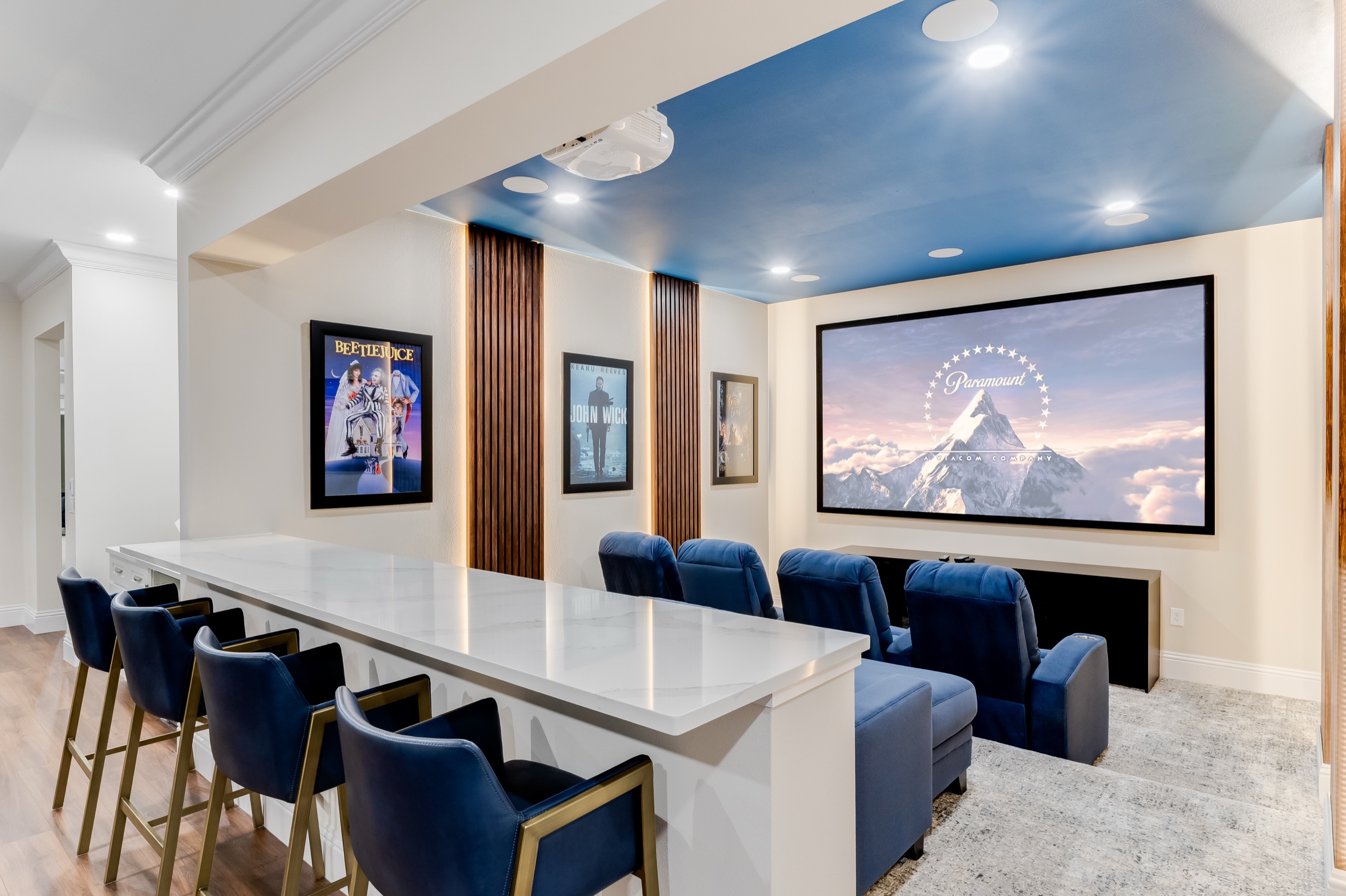 Gathering Loop — tiered home cinema with a wall-sized screen and blue seating