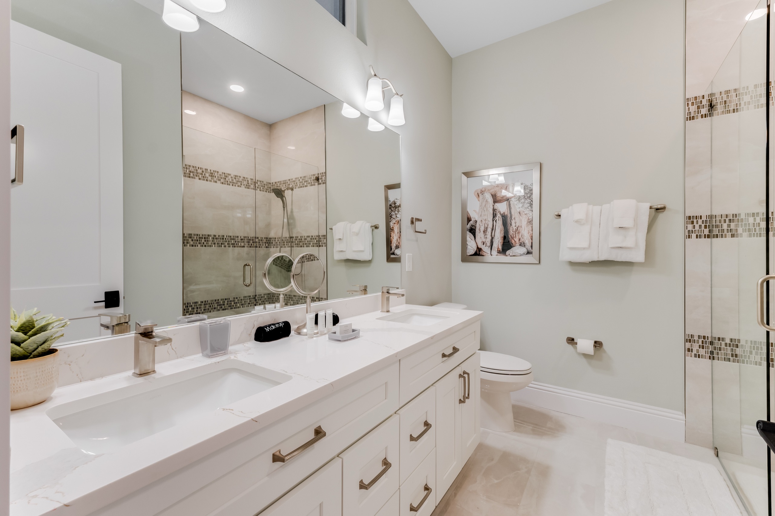 Downstairs suite bath with a dual vanity and glass shower
