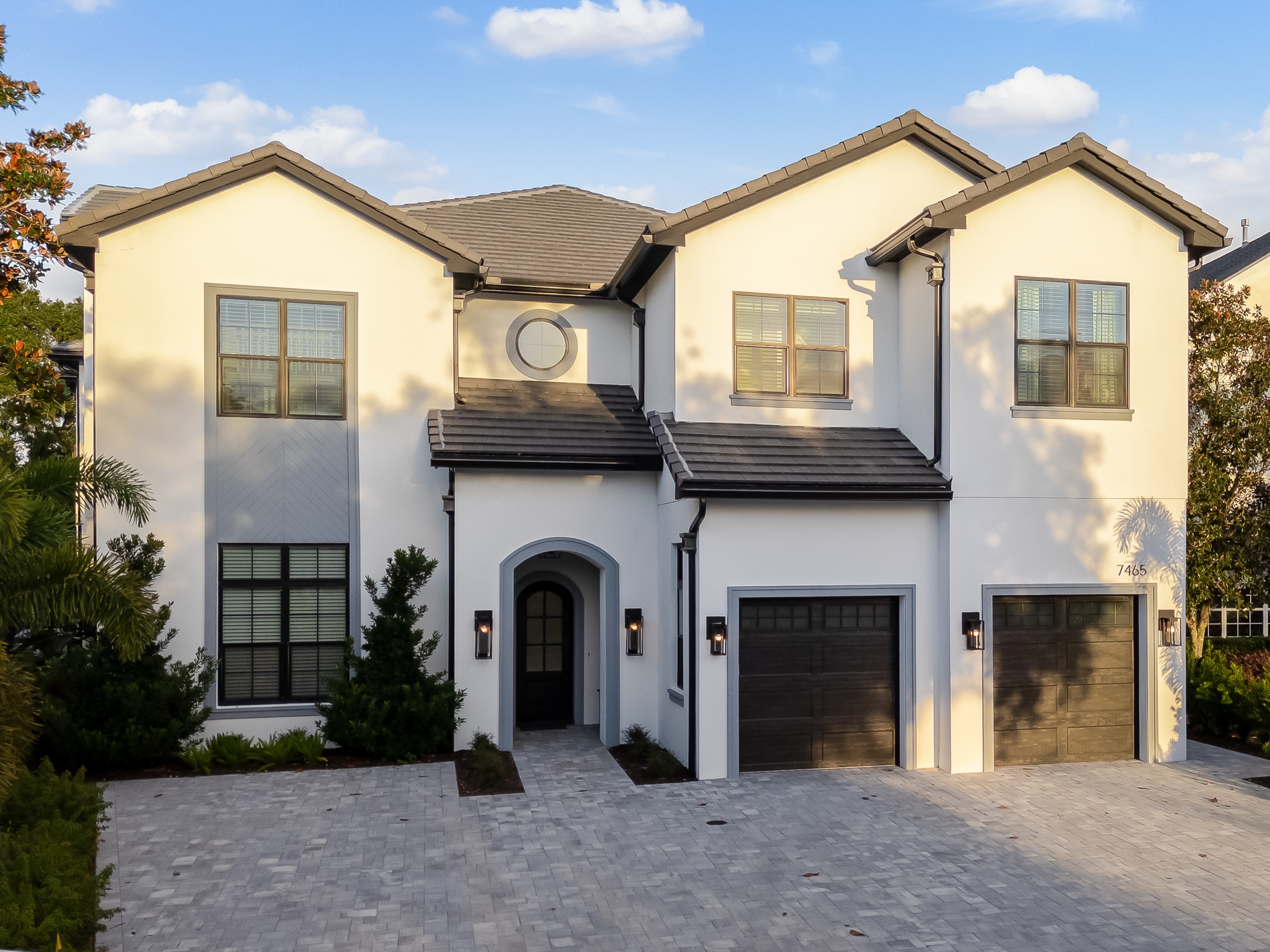 Gathering Loop — white golf-front residence with an arched entry under a clear sky