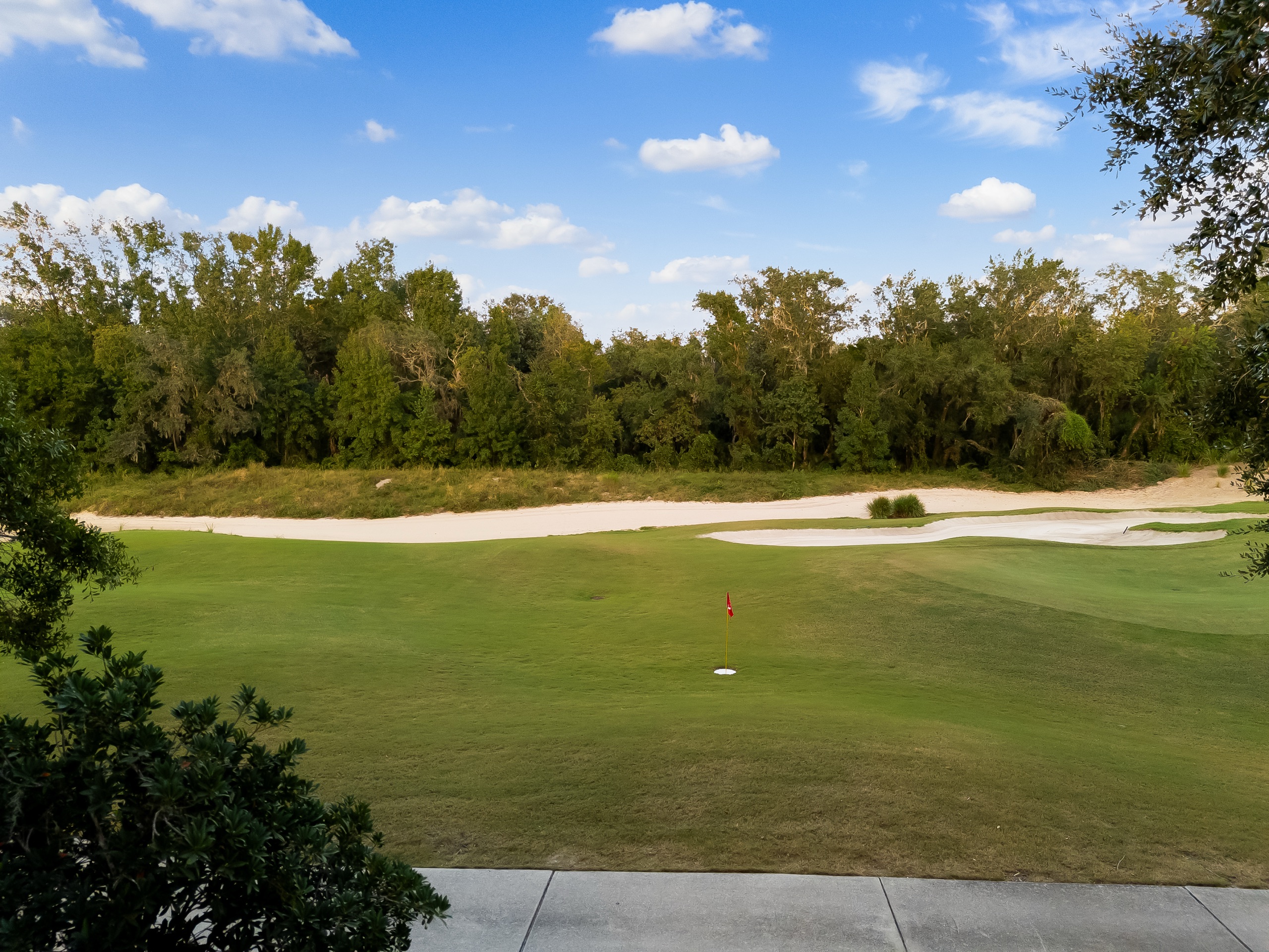 A putting green and bunker on the fairway just past the property
