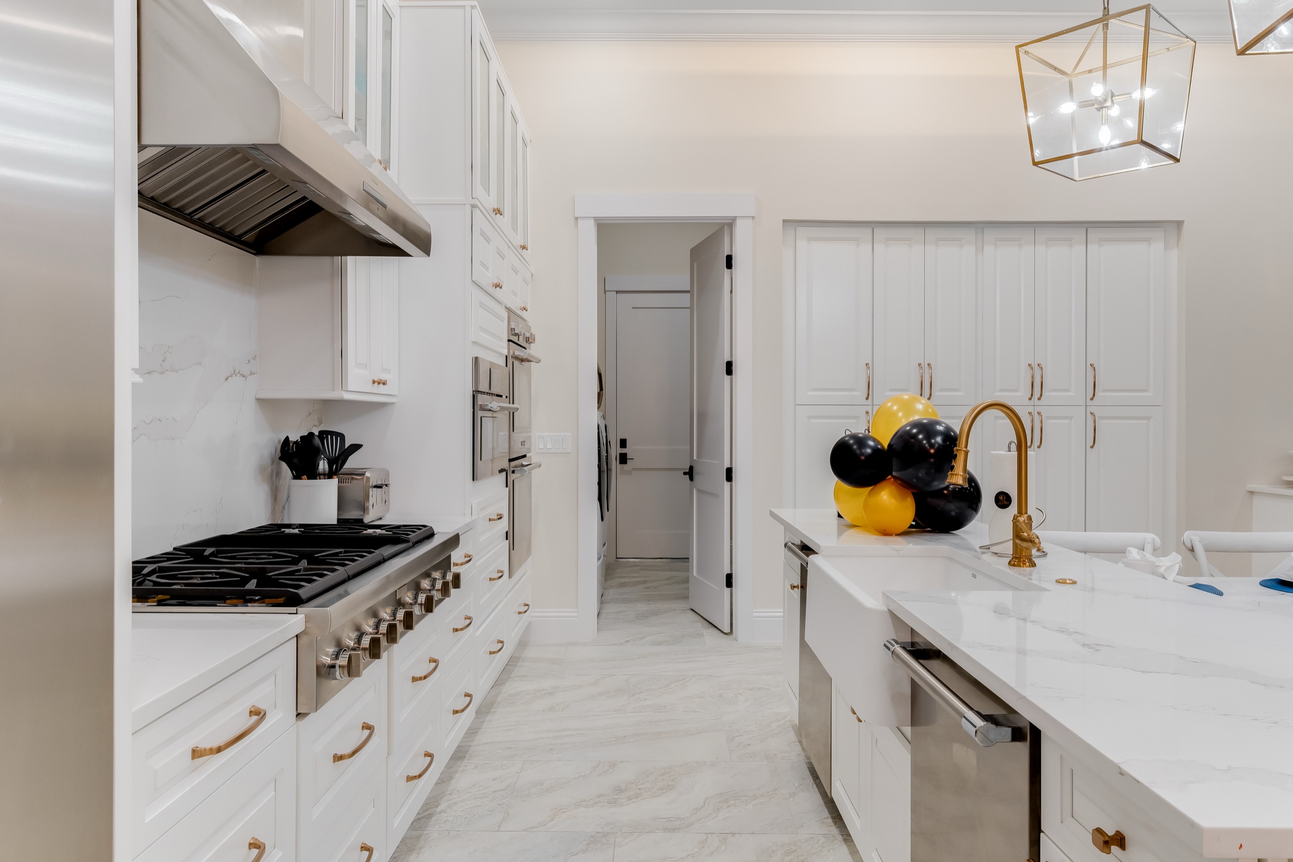 Chef's kitchen with a professional range, marble counters, and a stainless hood