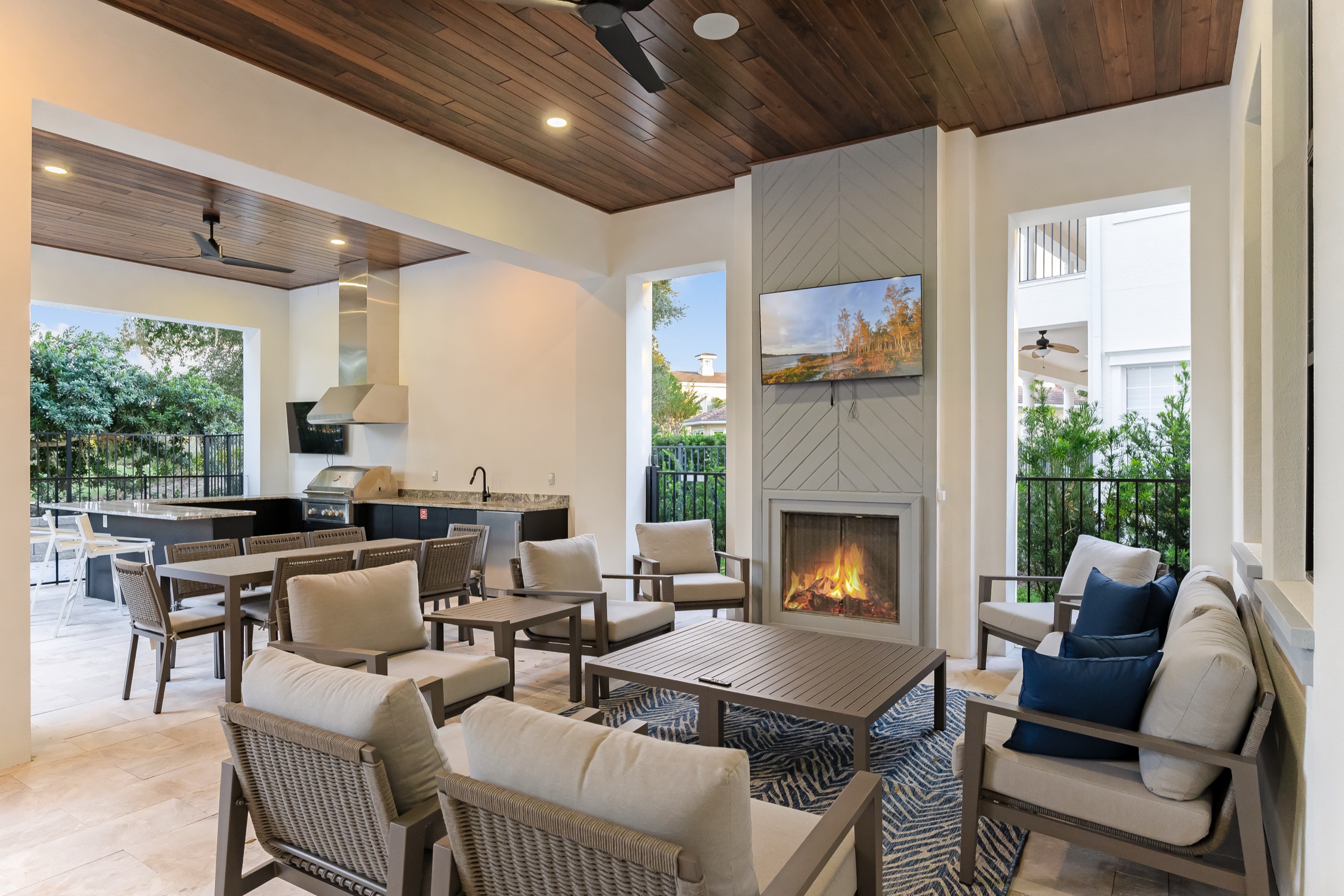 Lanai lounge with an outdoor fireplace and the summer kitchen beyond