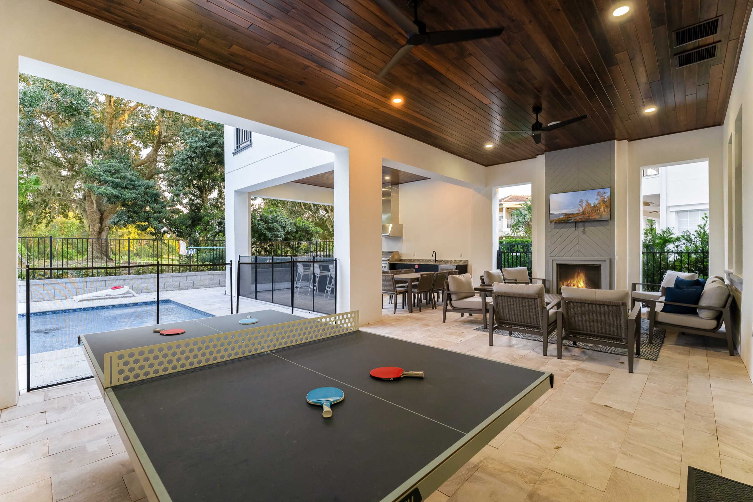 Covered lanai with a ping-pong table beside the fireplace lounge