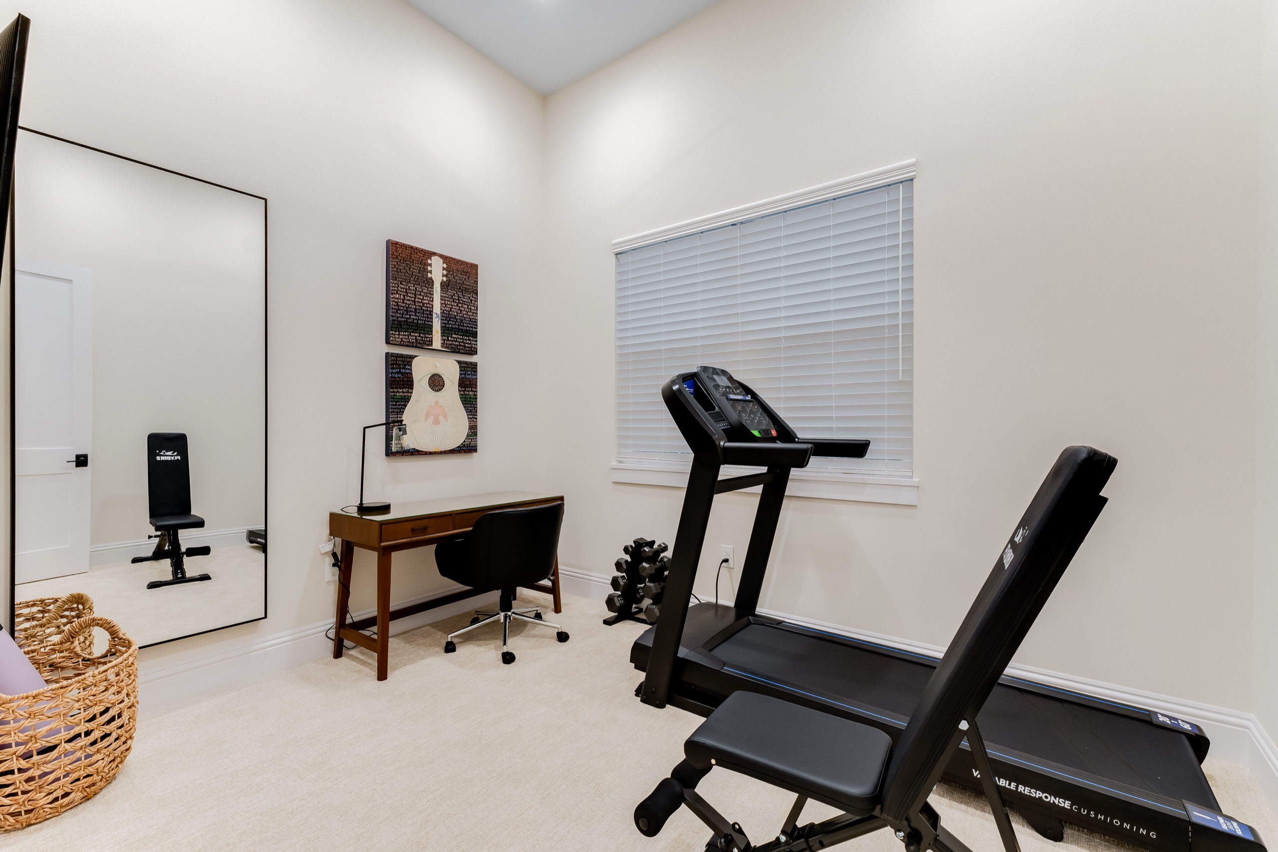 Office and workout space with a desk and a treadmill and weight bench