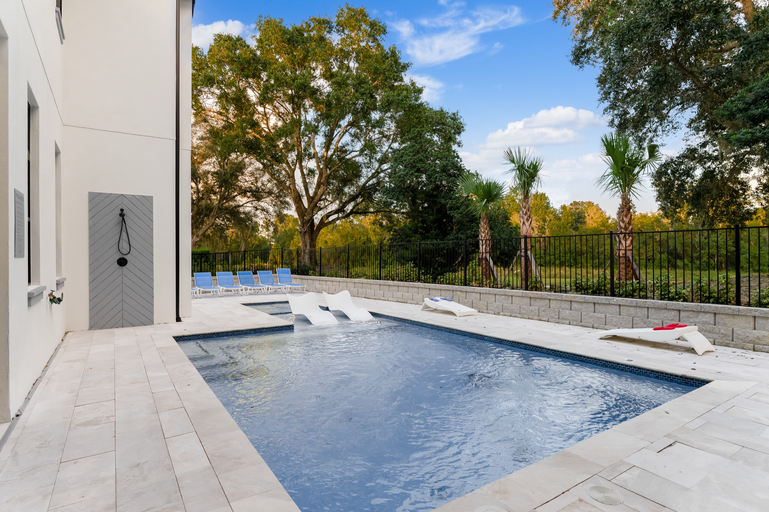 The travertine pool deck with the outdoor shower beyond