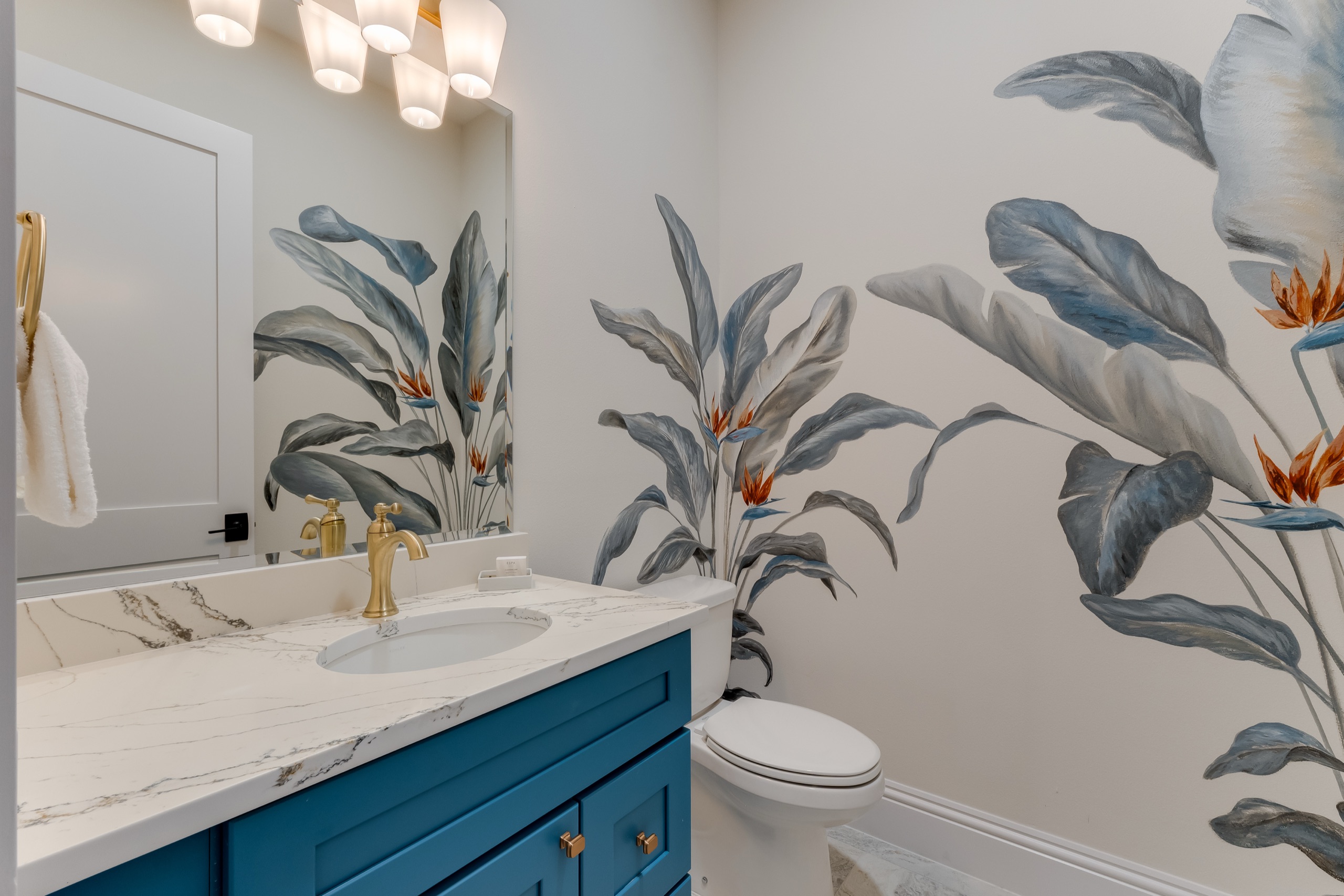Front powder bath with a hand-painted botanical mural and a blue vanity