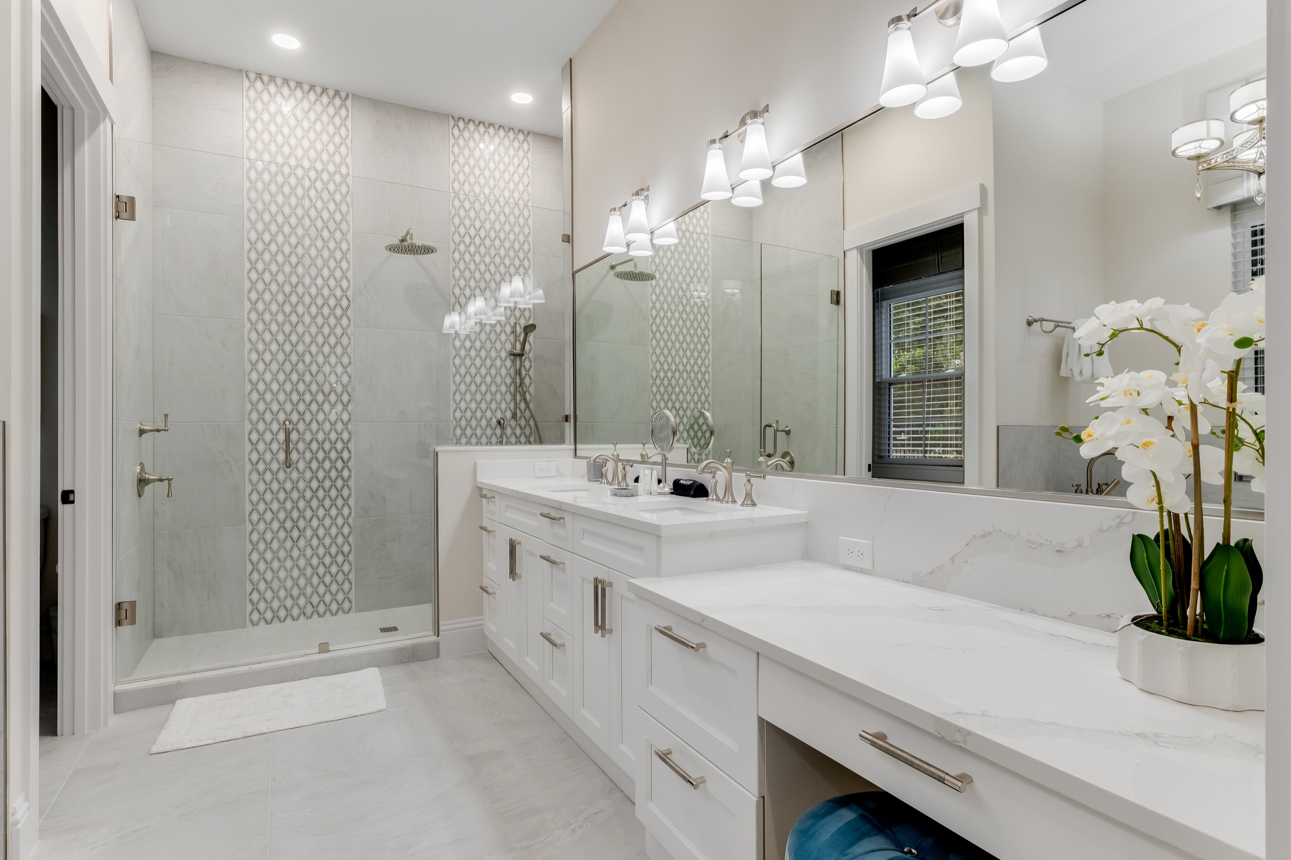 Upstairs suite bath with a dual vanity, glass shower, and an orchid