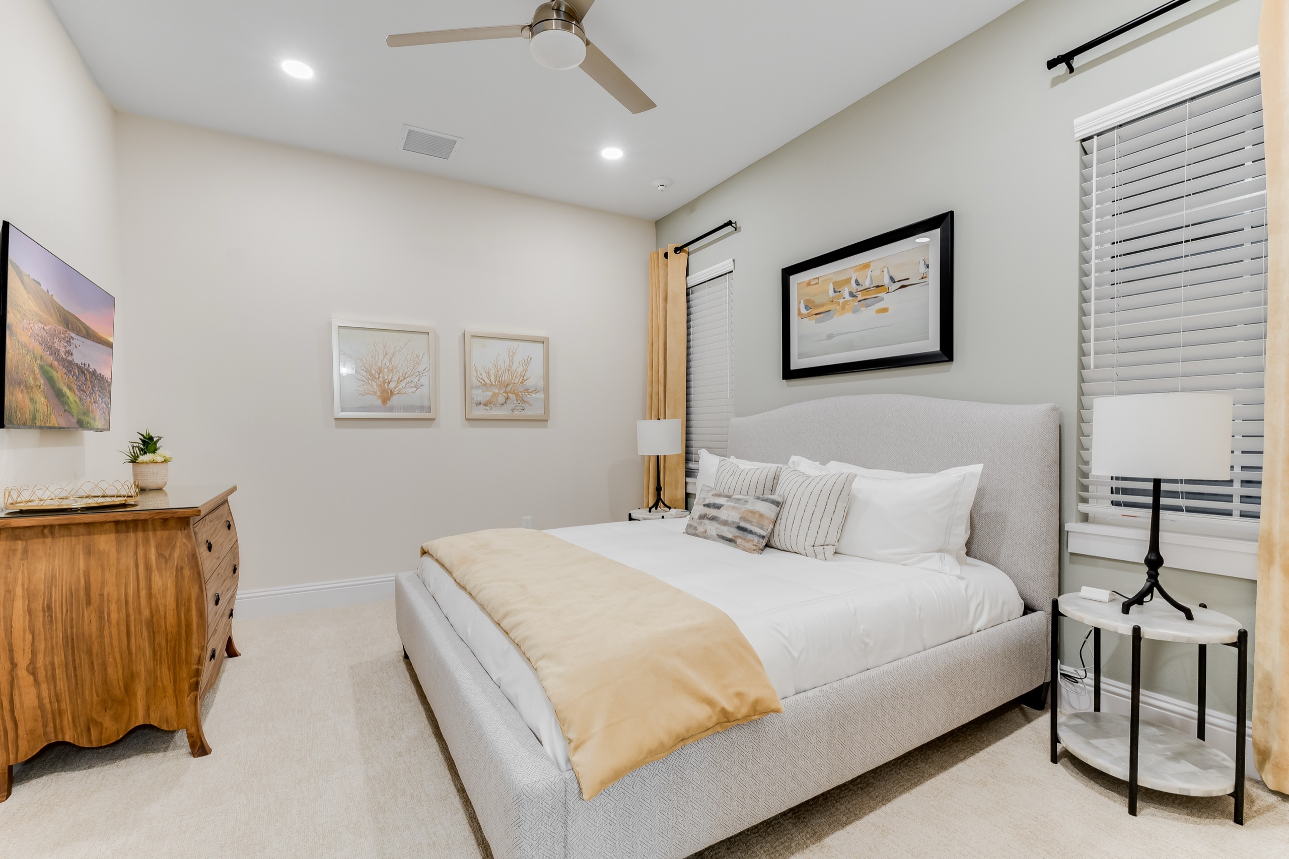 Guest suite in warm neutrals with a wood dresser