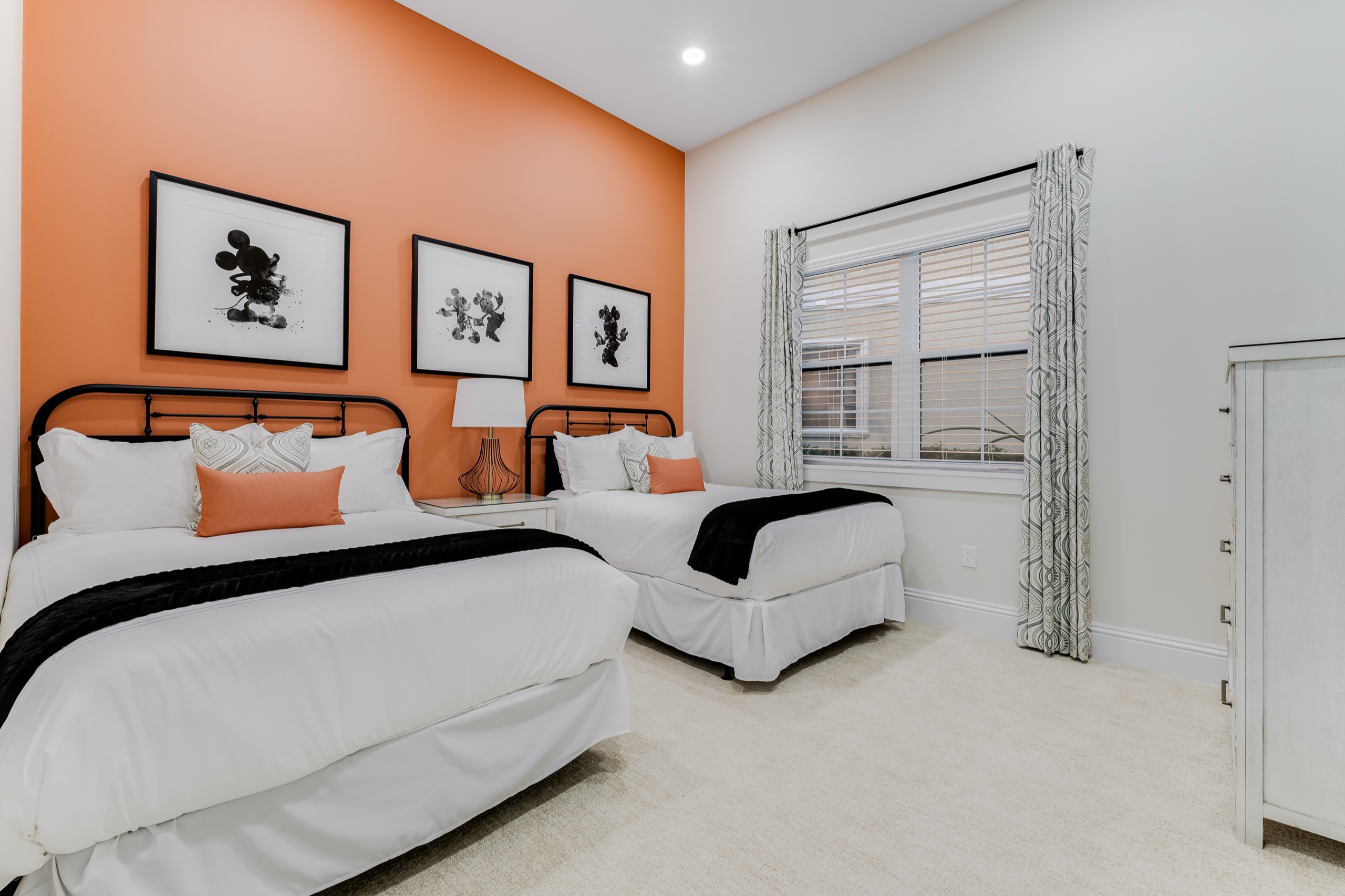 Twin guest room with an orange accent wall and two beds