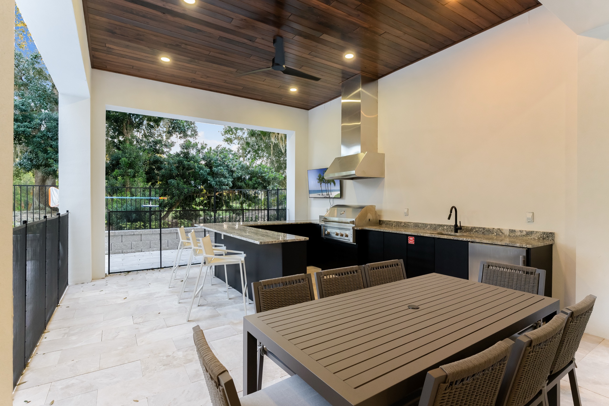 Covered terrace dining set beside the summer kitchen and pool
