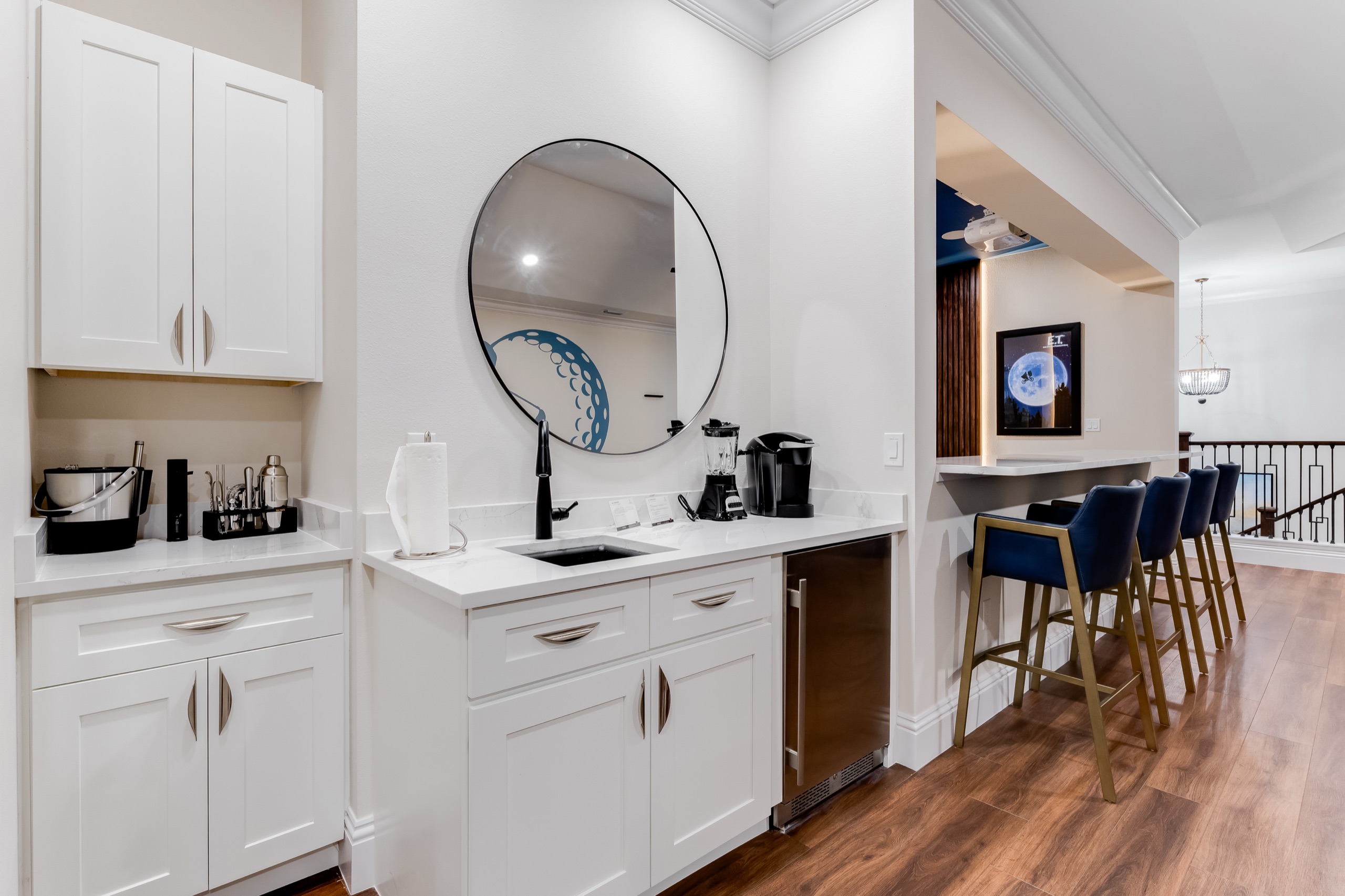 Second-floor wet bar with blue counter stools off the game floor