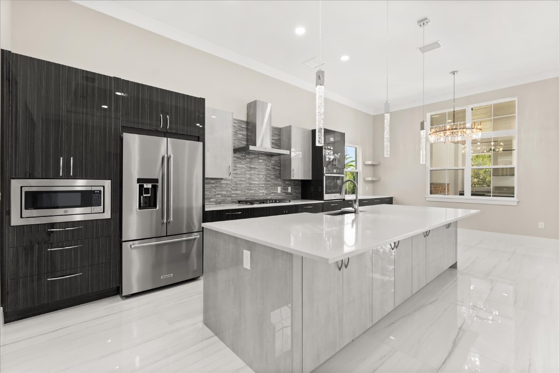 Kitchen with a long marble island and a chandelier-lit dining nook