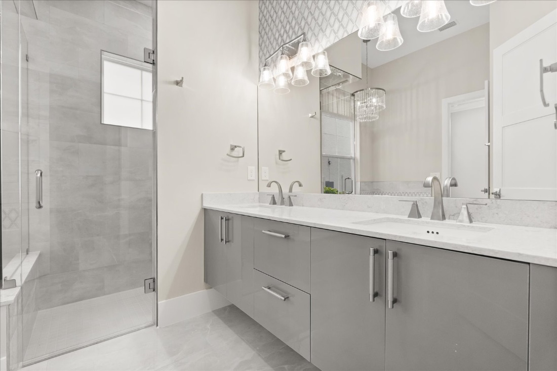 Double vanity beside a glass walk-in shower
