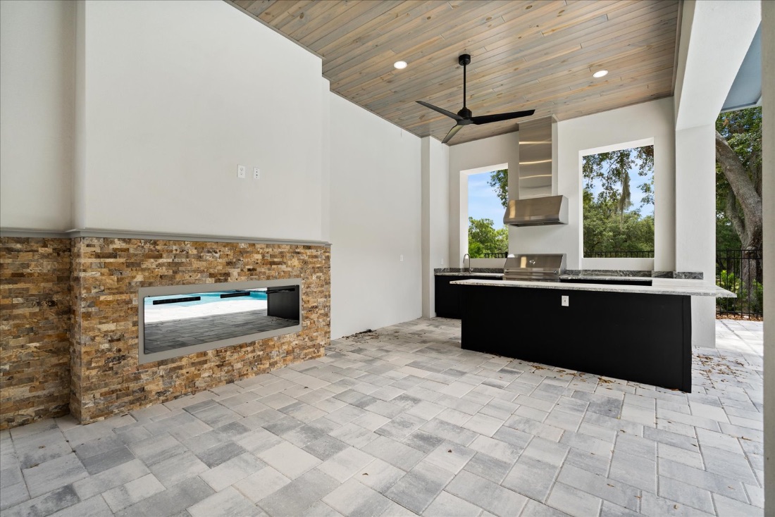 Summer kitchen with a stacked-stone linear fire feature
