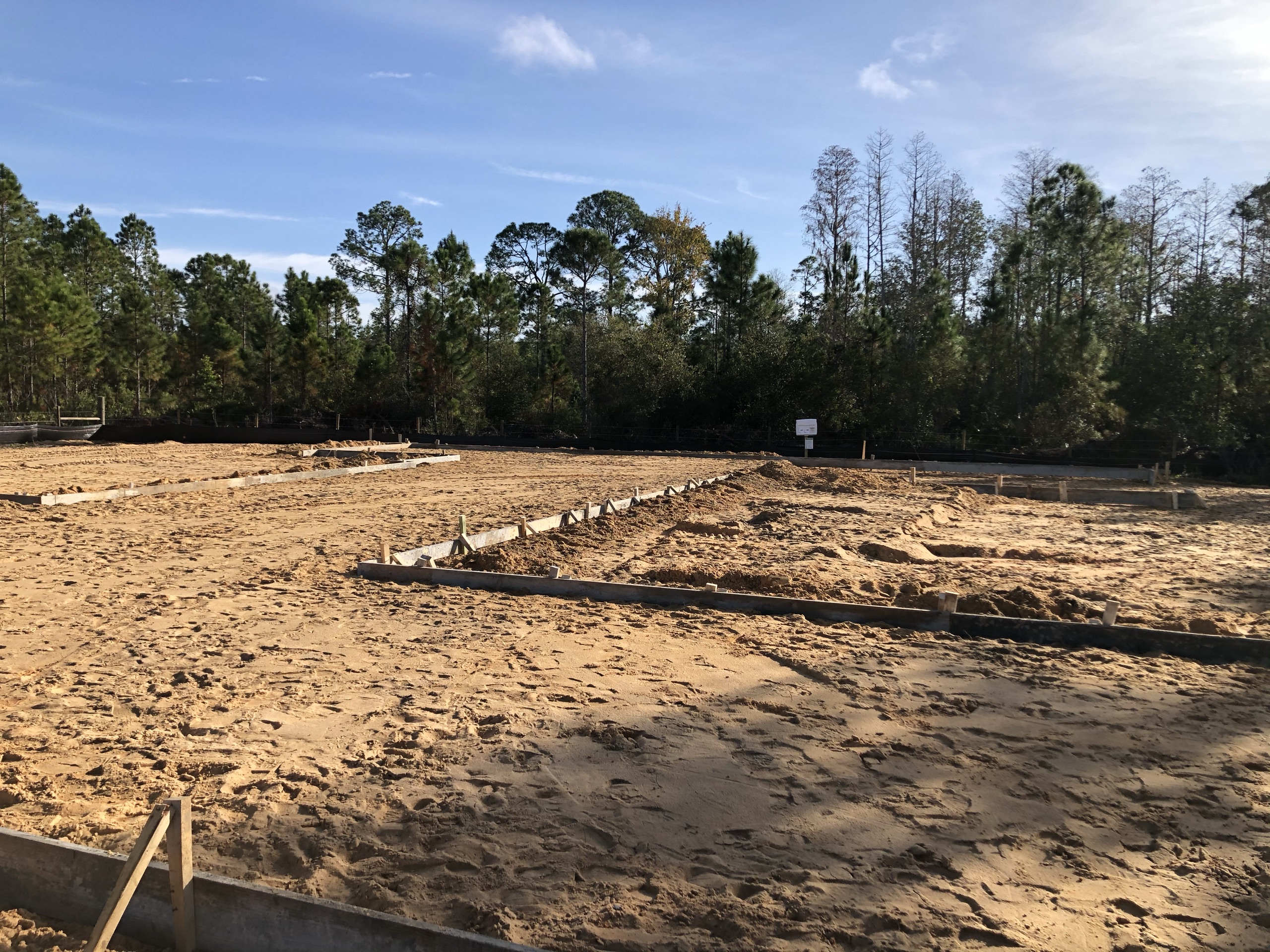 A cleared and staked lot with footing forms set, ready to begin construction