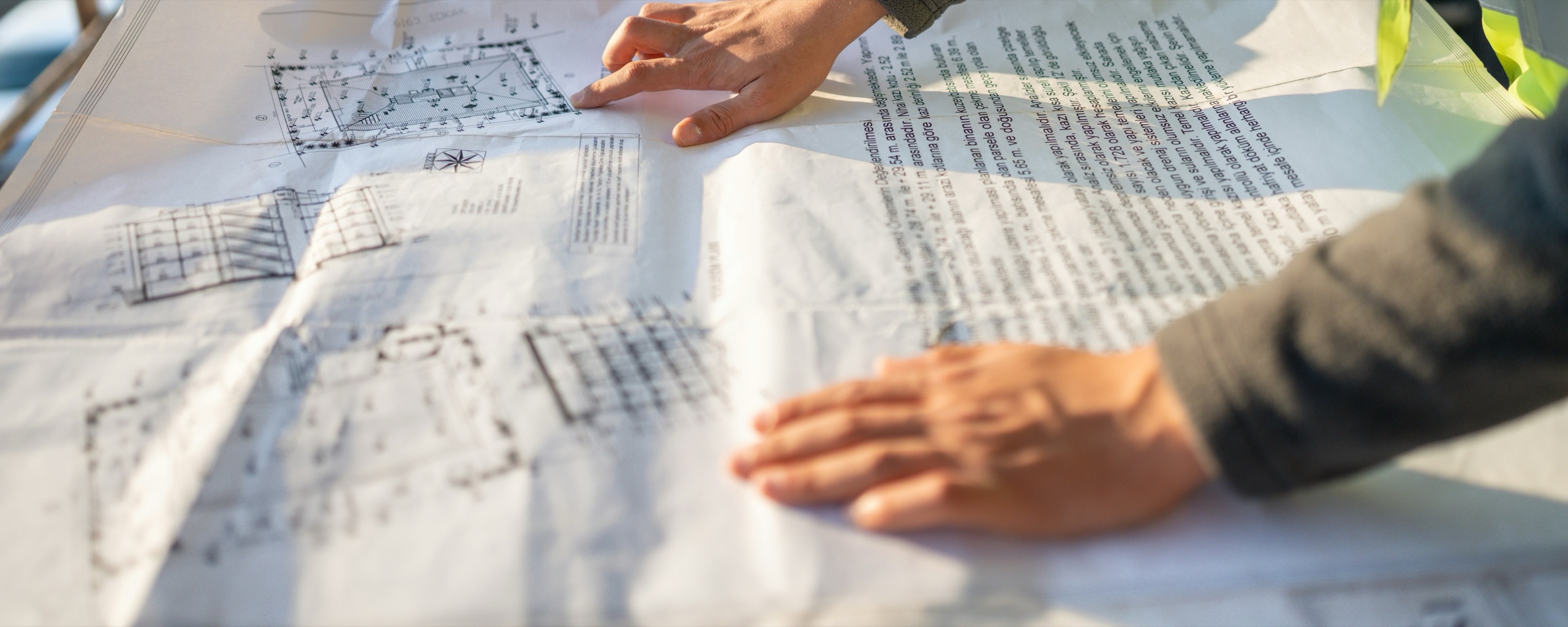 Hands reviewing plans together on a job site