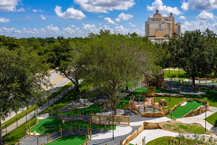 Reunion's mini-golf and adventure playground, with the grande hotel rising beyond the oaks