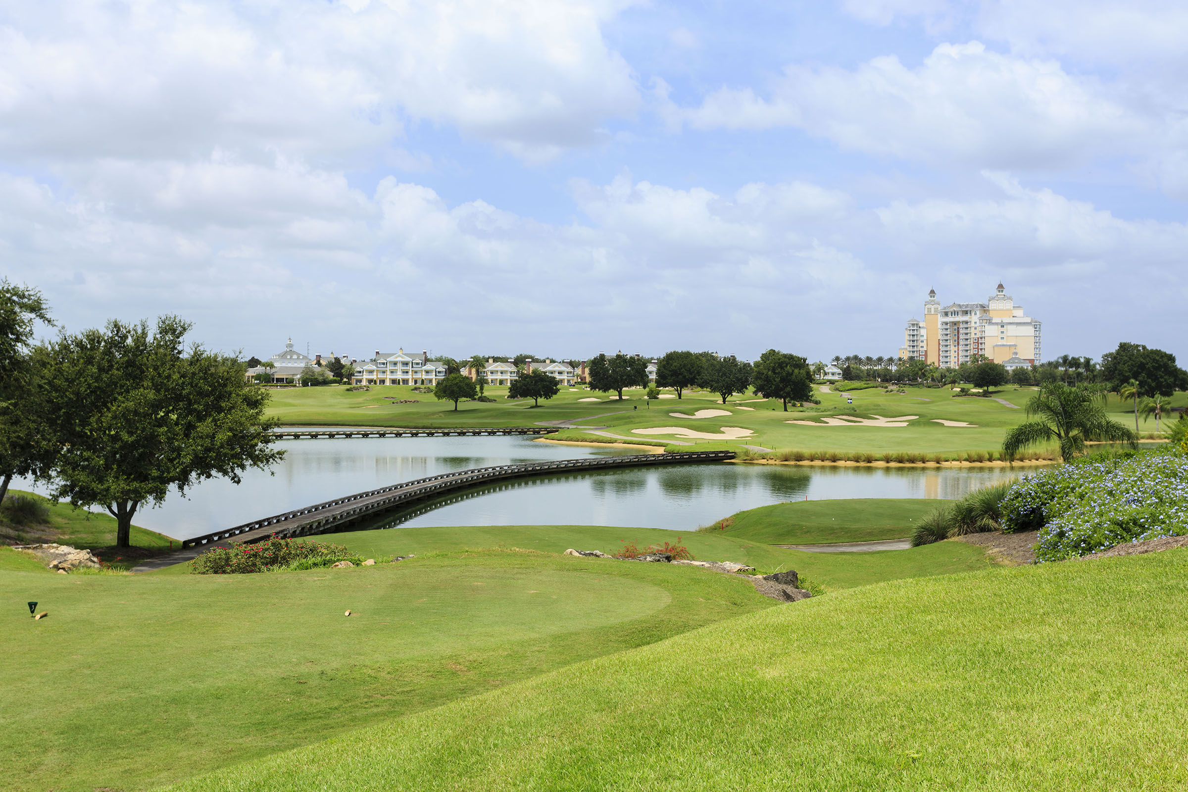 The Palmer course at Reunion Resort — the boardwalk bridge crossing the lake toward villas and the grande hotel
