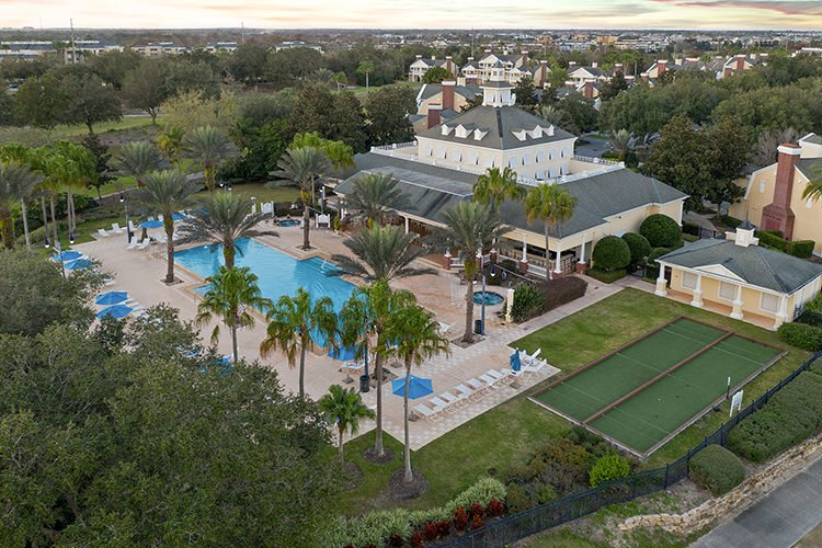 Seven Eagles pool and clubhouse from above — lap pool, spa, and bocce court among the palms
