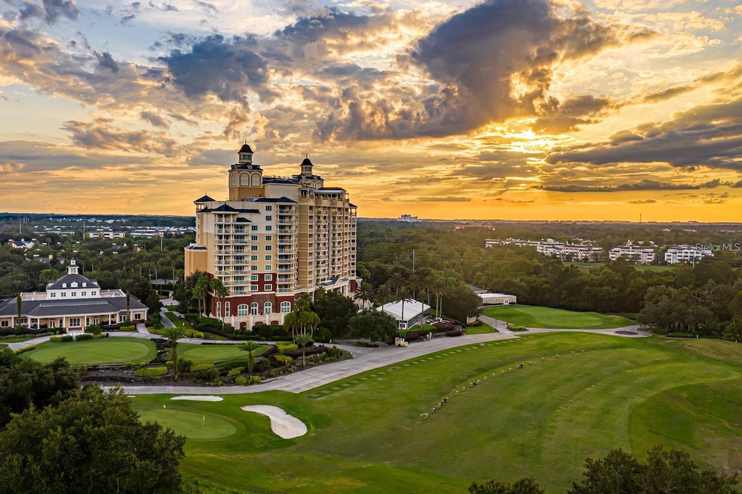 Reunion Way at dusk — the resort's grande hotel and clubhouse above the practice green and fairways