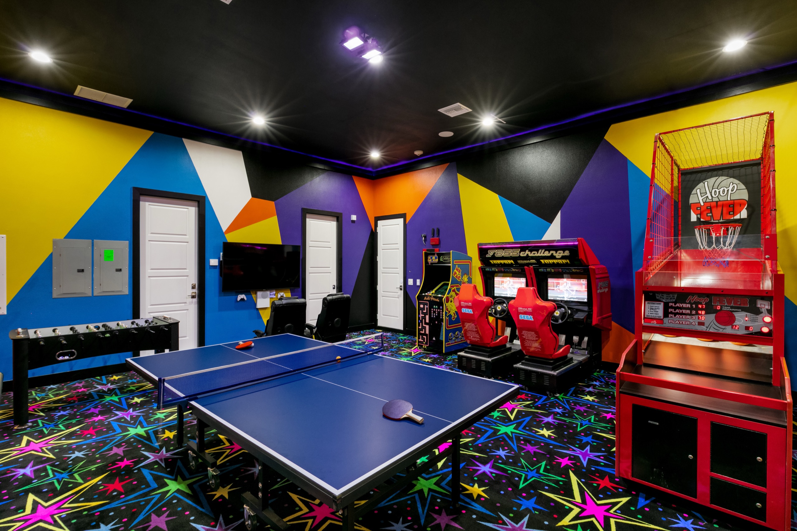 Games room with ping-pong, foosball, racing arcades, and a Hoop Fever basketball game on star-print carpet