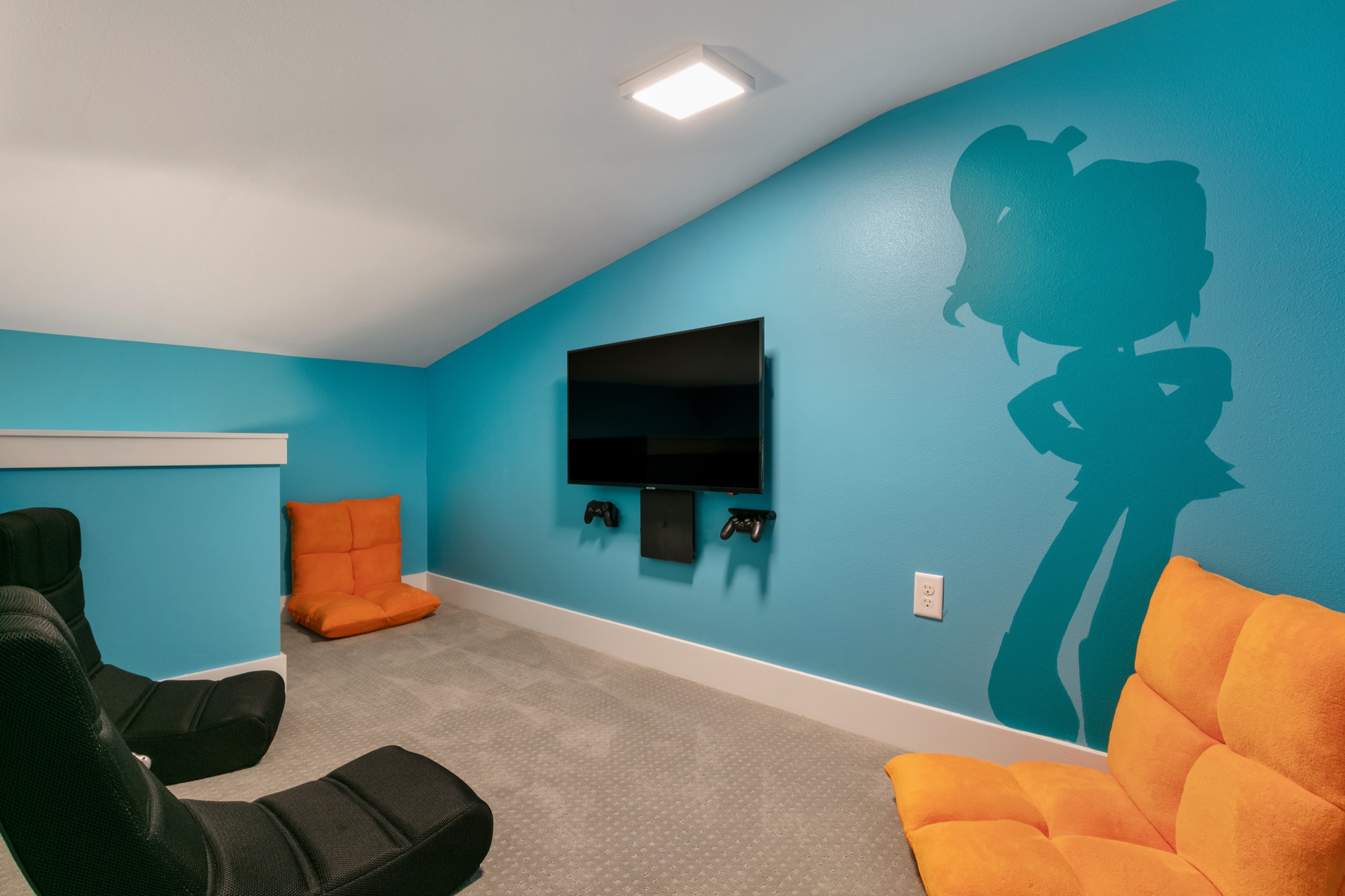 Themed game lounge with a painted character mural and gaming chairs