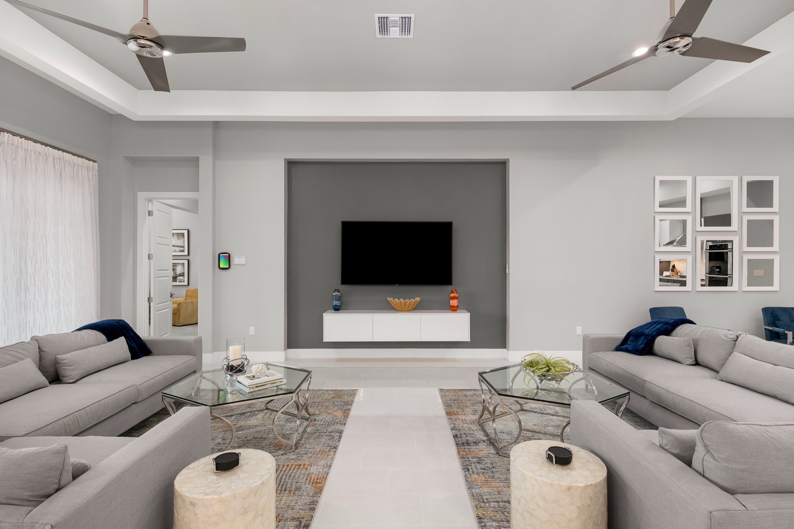 Living lounge with twin gray sofas facing the recessed media wall, another view