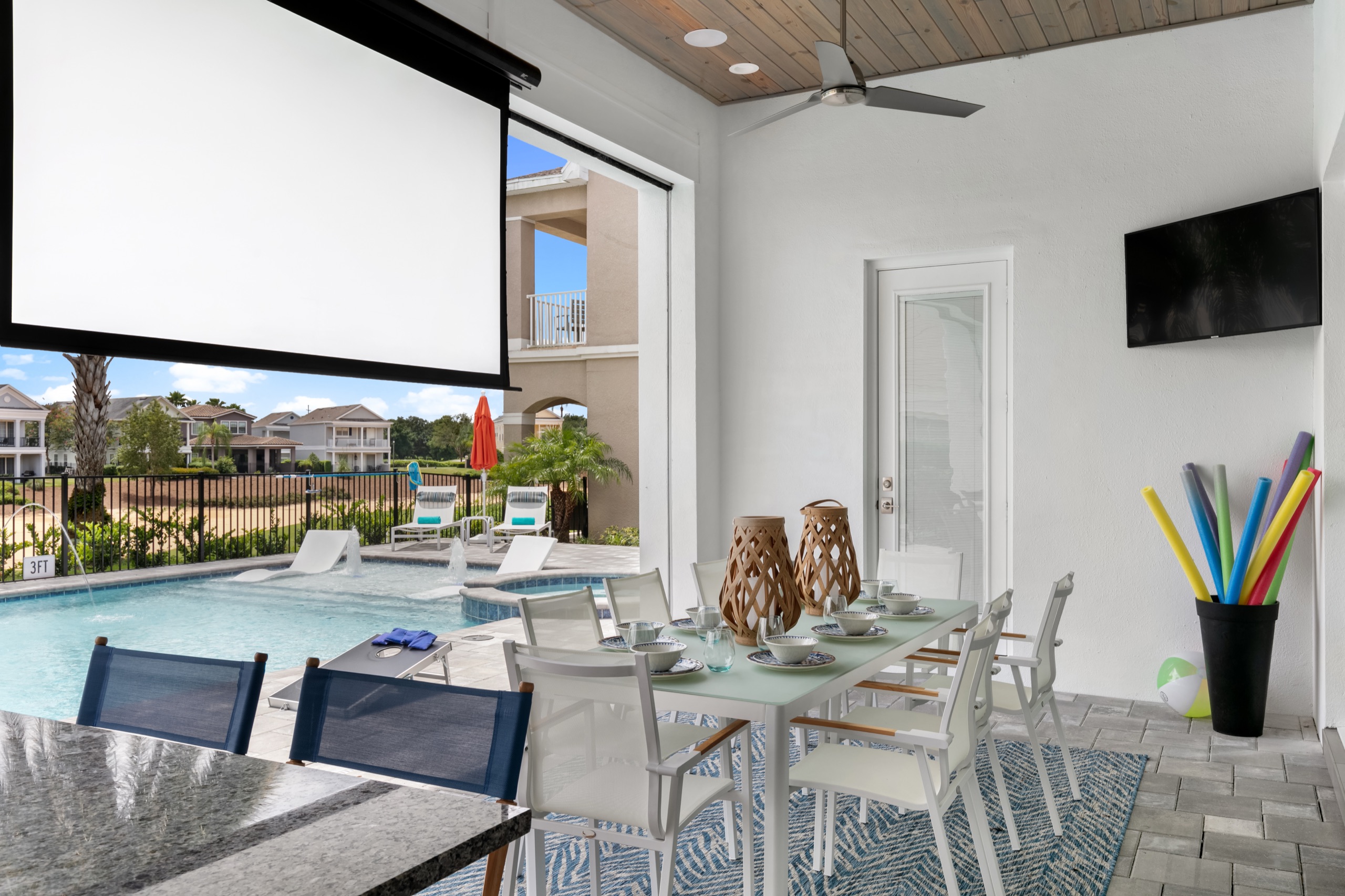 Covered lanai with a drop-down projector screen overlooking the pool
