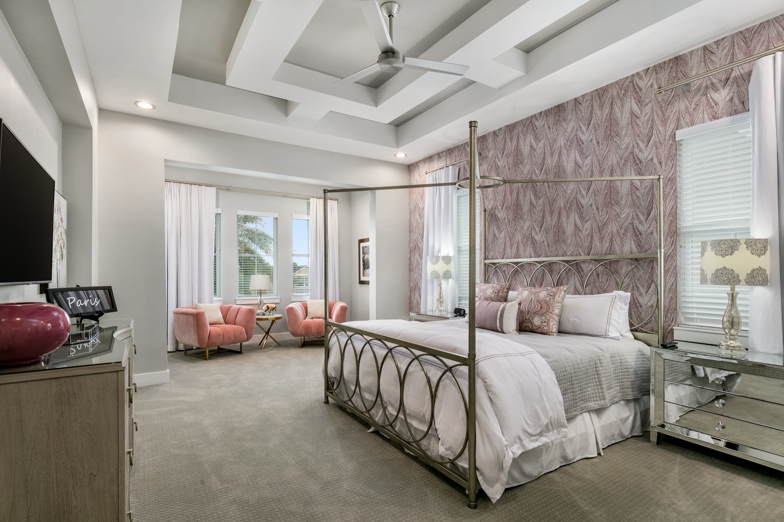 Paris suite with a champagne canopy bed, blush accents, and a pink-upholstered sitting area